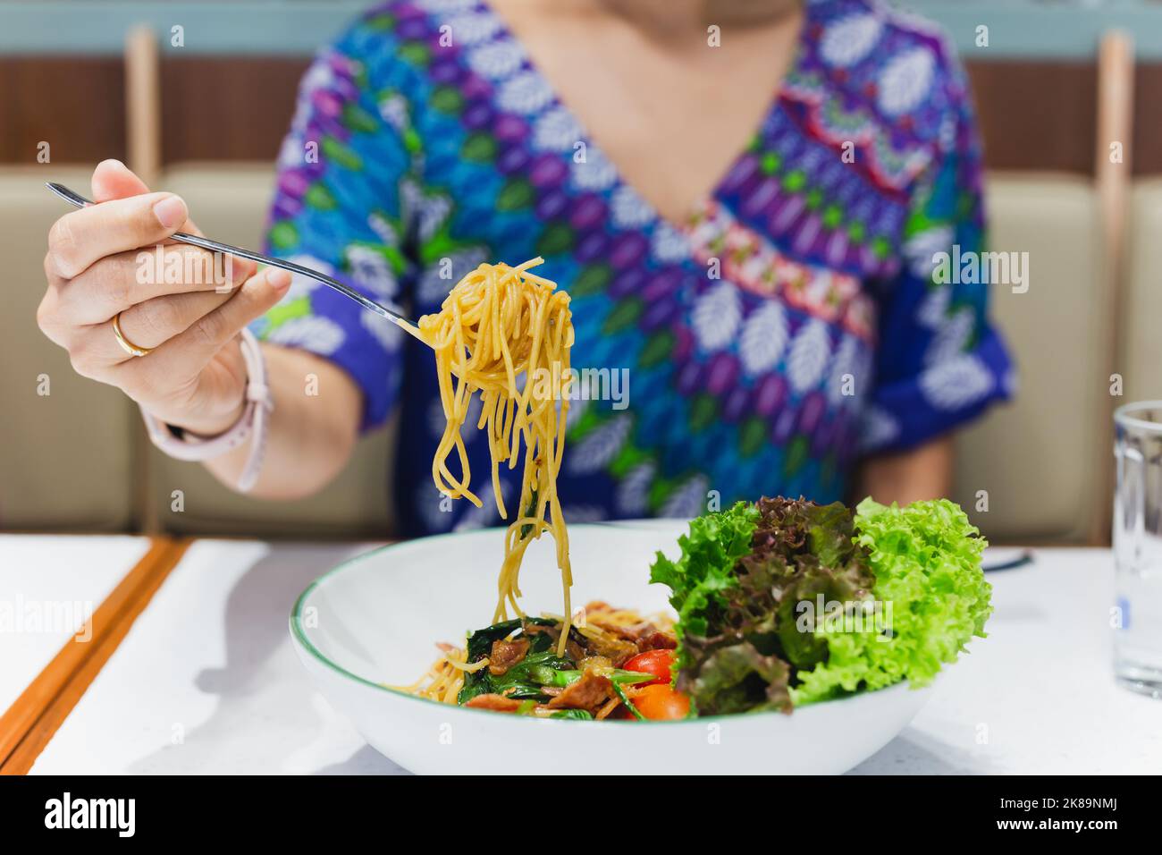 Hand hält Gabel essen Spaghetti im Restaurant. Stockfoto