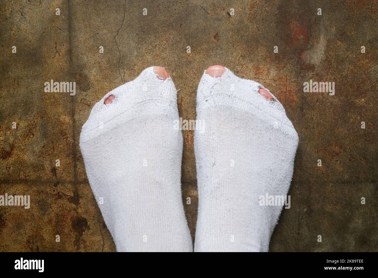 Mann Zehen stochen durch Löcher in weißen Socken, Härtekonzept Stockfoto