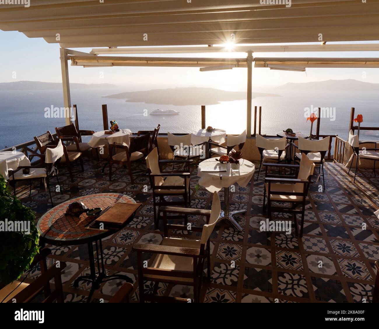 Restaurant mit Blick auf die Caldera in der Stadt Fira bei Sonnenuntergang. Griechische Kykladen-Insel Santorin in der Ägäis Stockfoto