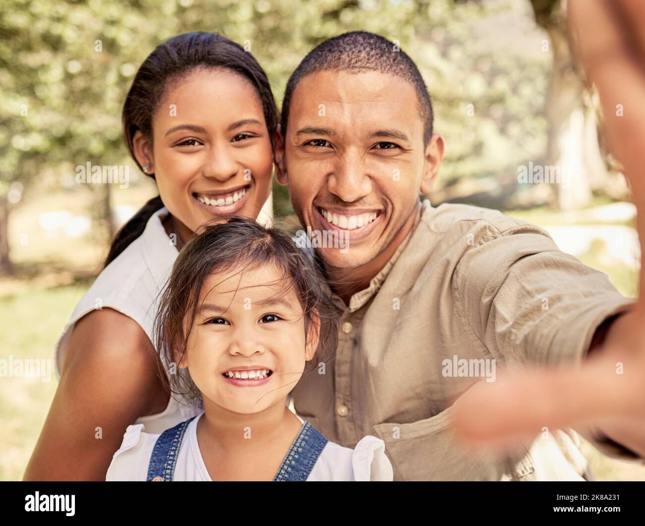 Selfie, Familie und Park mit einem schwarzen Paar und einem asiatischen Mädchen, das für ein Foto im Freien posiert. Kinder, Bild und Sommer mit Stockfoto