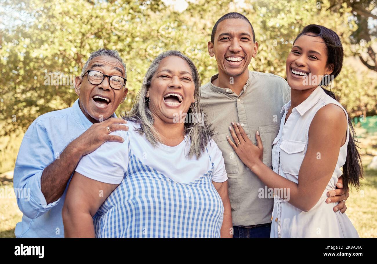 Glückliche Familie, lachen und entspannen Sie sich in einem Park zusammen mit einem Paar, das sich mit älteren Eltern in der Natur verbindet. Liebe, Familie und Wiedersehen in einem Wald mit Stockfoto