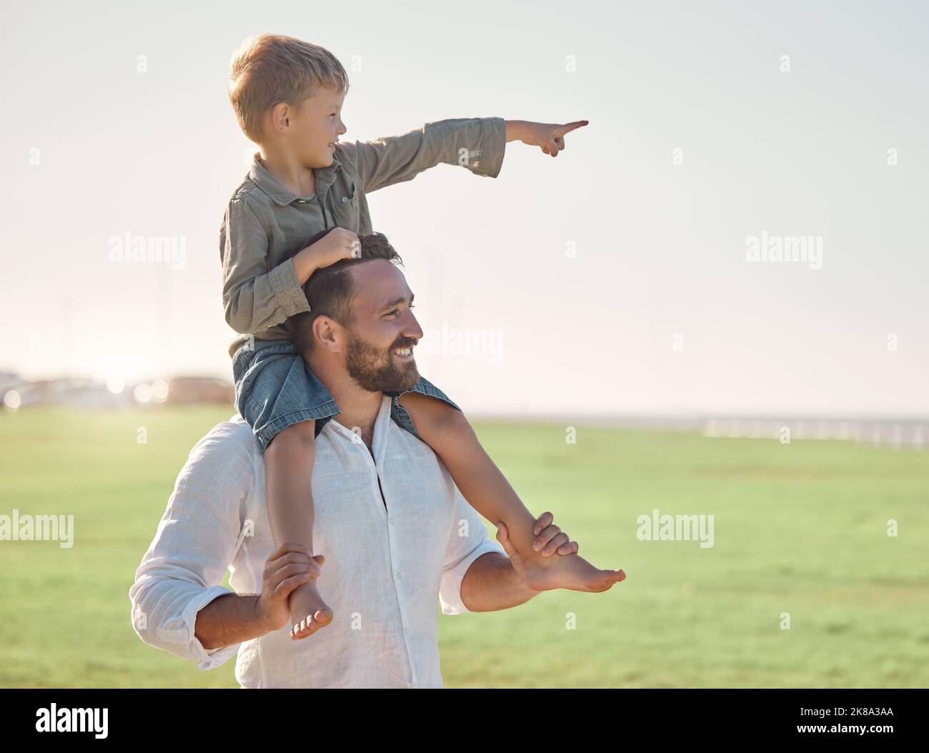 Vater, Kind und die Verbindung im Freien in der Natur mit einem Blick mit Glück und Familie Pflege. Glücklicher Vater und Kind zusammen mit einem Lächeln genießen einen Sommer Stockfoto