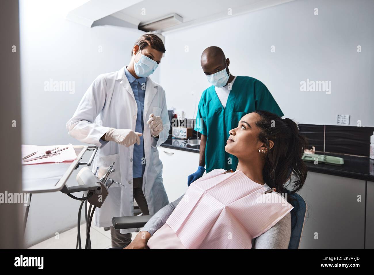 Ein kurzer Chat beruhigt die Patienten. Eine junge Frau, die sich mit ihrem Zahnarzt beraten lässt. Stockfoto