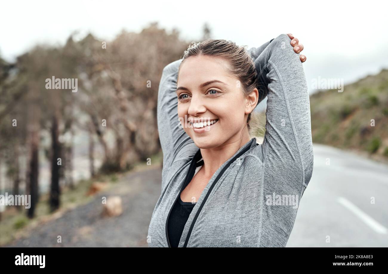 Erhöhung der Beweglichkeit ihrer Gelenke und Muskeln. Eine sportliche junge Frau streckt ihre Arme beim Training im Freien. Stockfoto