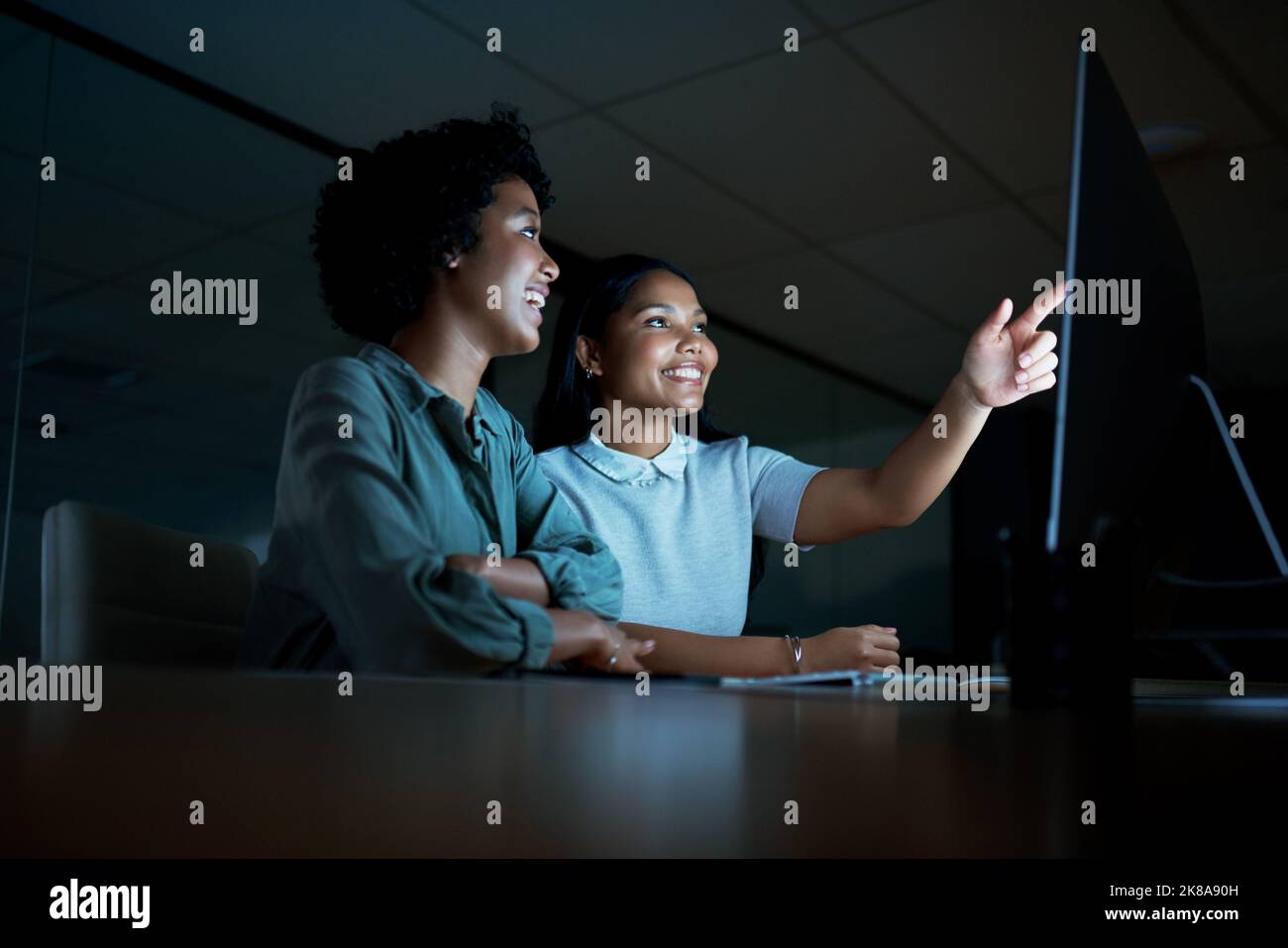 Erfolgreiche Menschen blicken nach vorne und nicht zurück. Zwei junge Geschäftsfrauen benutzen einen Computer zusammen während eines späten Abends bei der Arbeit. Stockfoto