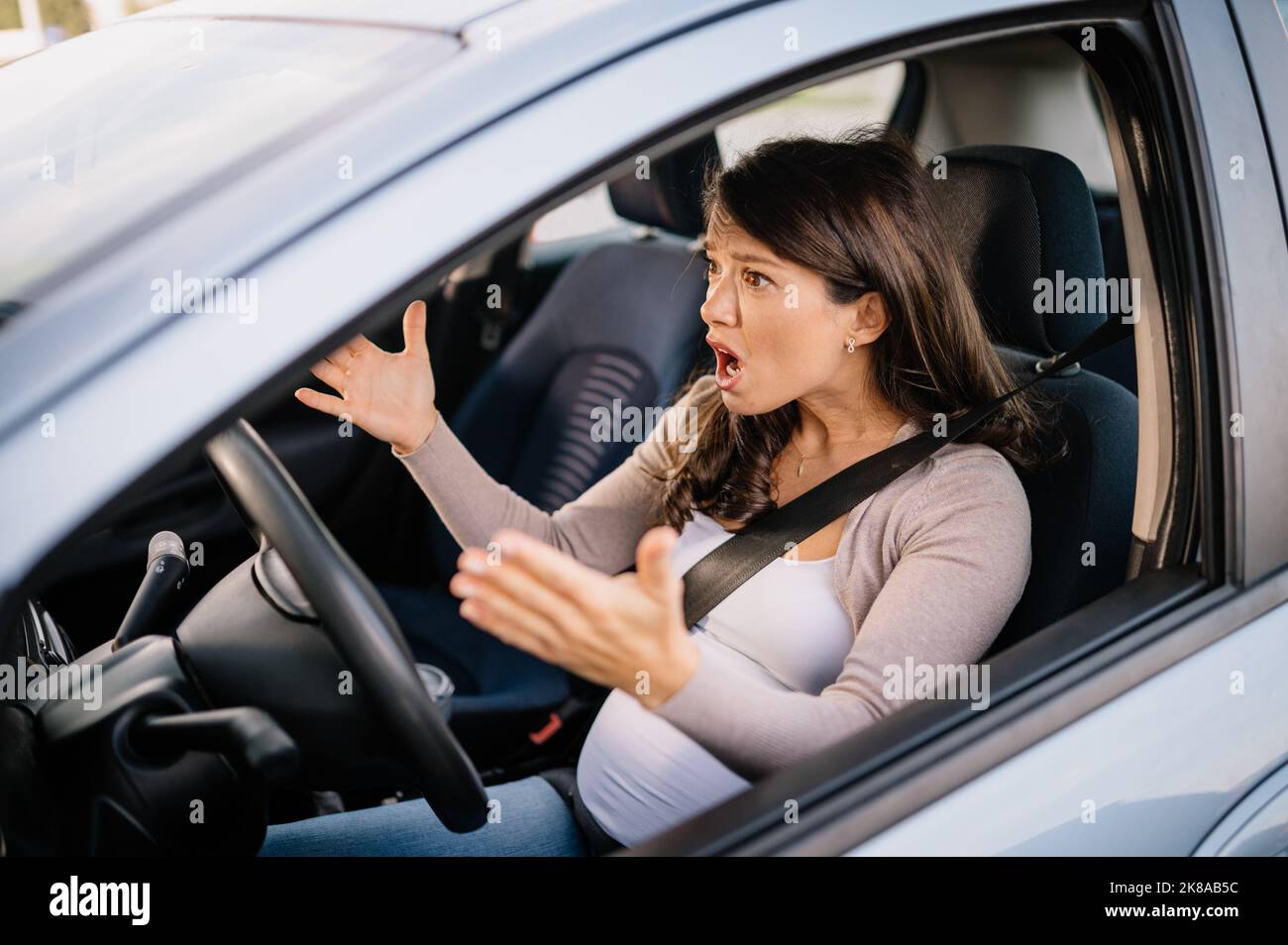 Schwanger kaukasische Frau mit wütenden Gesicht im Auto sitzen Stockfoto