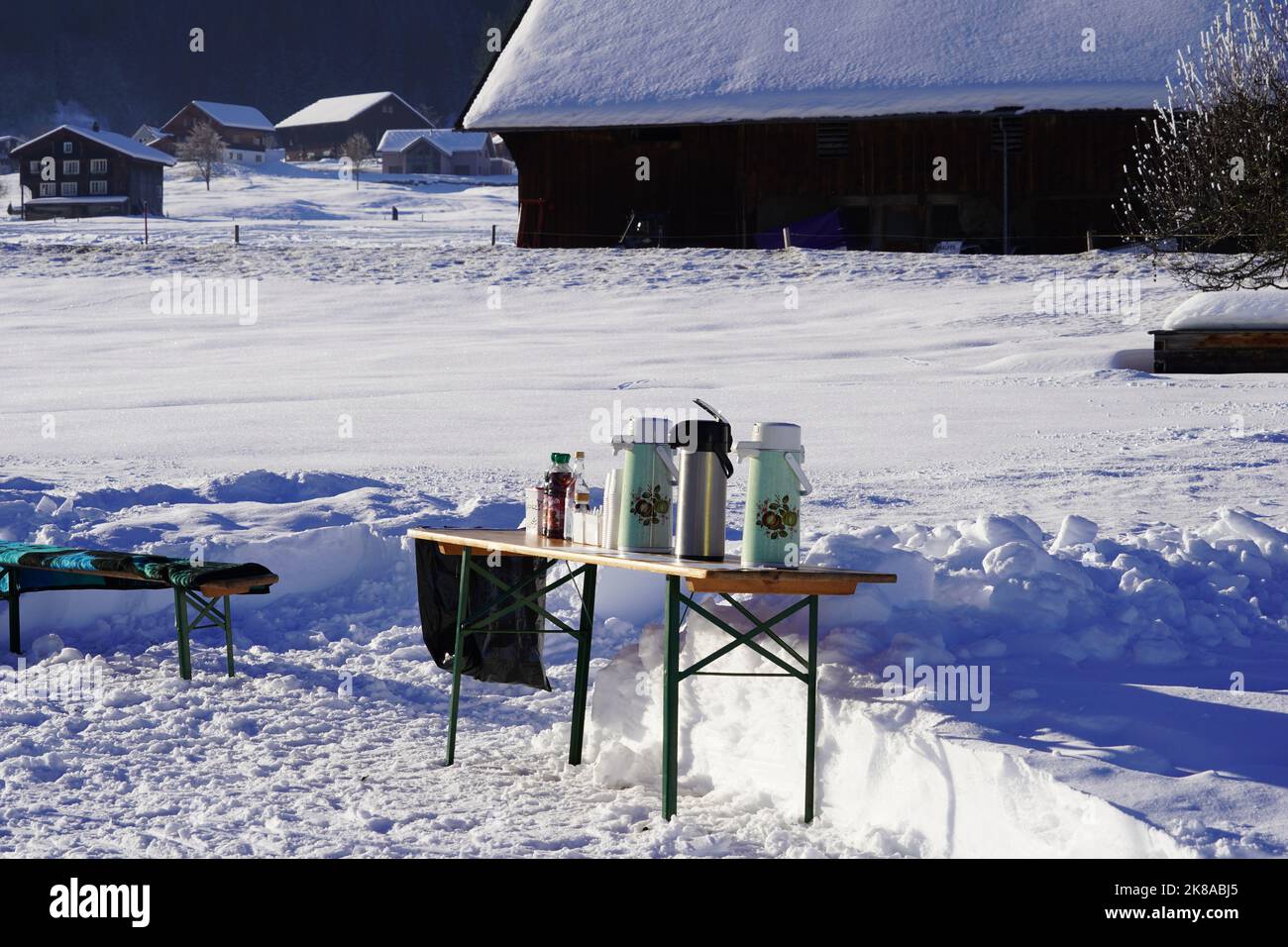 Tische mit erfrischenden Getränken auf der Loipe im Ferienort Studen, Kanton Schwyz. Stockfoto