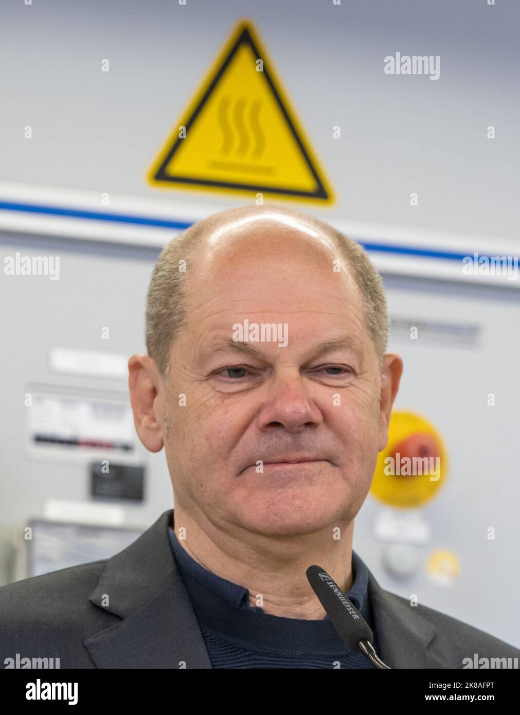 München, Deutschland. 22. Oktober 2022. Bundeskanzler Olaf Scholz steht bei seinem Besuch im Ausbildungszentrum der Handwerkskammer unter einem Schild mit der Aufschrift „Warnung vor heißer Oberfläche gemäß ISO 7010 (W 017)“. Kredit: Peter Kneffel/dpa/Alamy Live Nachrichten Stockfoto