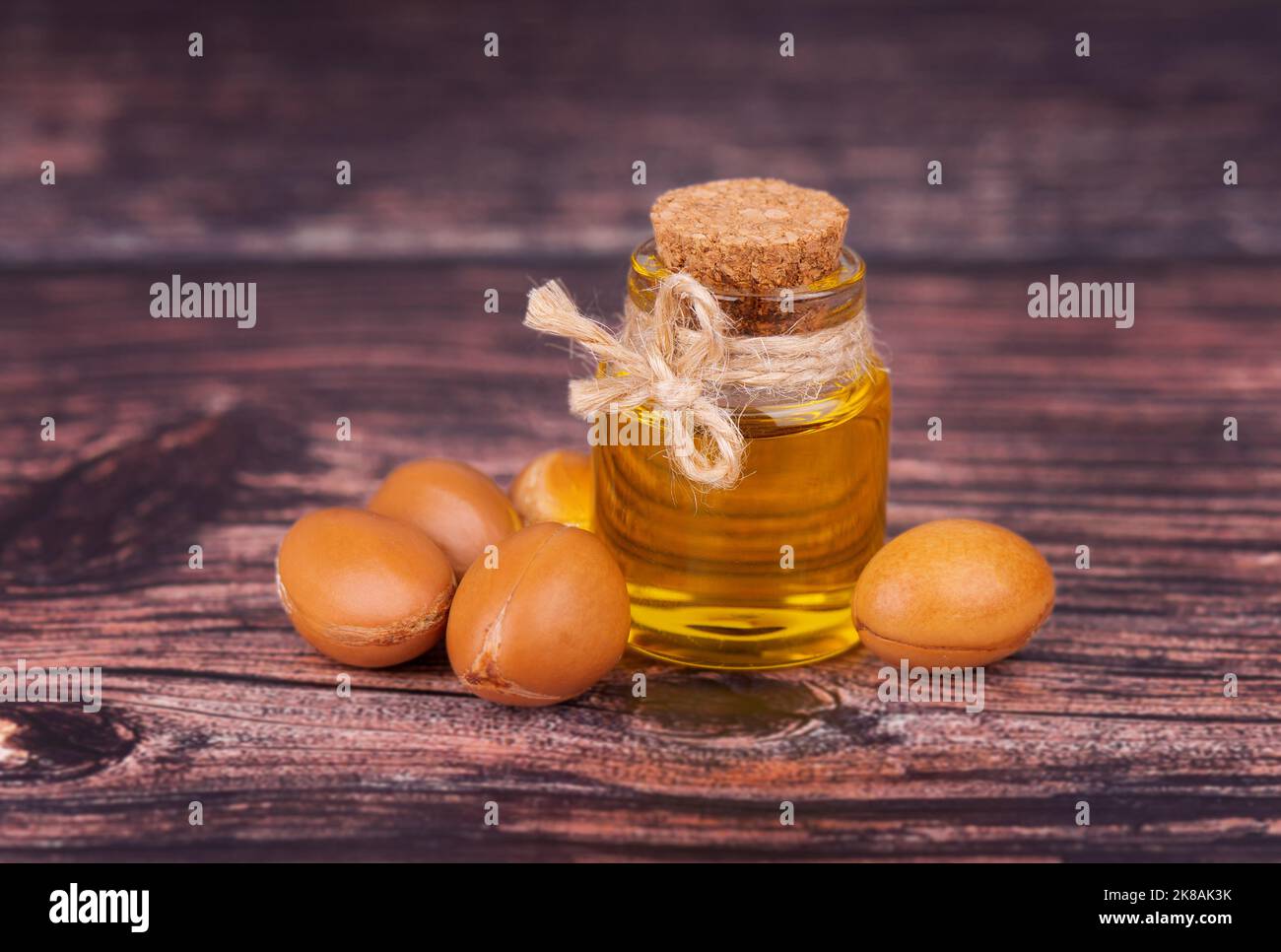 Arganöl auf Holzgrund. Argan-Nüsse und -Samen, für Kosmetik- und Kosmetikprodukte. Natürliche Arganfrucht aus Marokko. Stockfoto