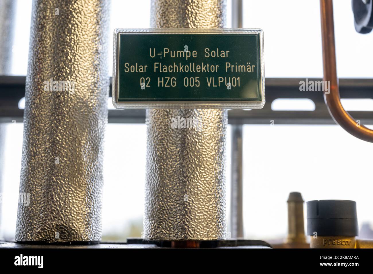 22. Oktober 2022, Bayern, München: Ein Schild mit der Aufschrift 'U-Pump Solar - Solar Flat Plate Collector Primary 02 HZG 005 VLPU01' ist an einem isolierten Rohr im Ausbildungszentrum der Handwerkskammer festgeklebt. Foto: Peter Kneffel/dpa Stockfoto