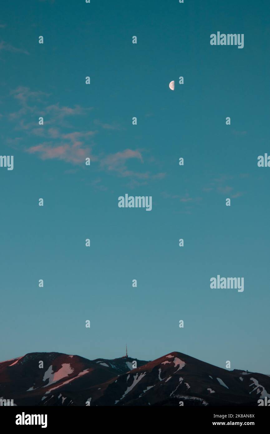 Halbmond im klaren blauen Morgenhimmel über dem Palandoken Berg Stockfoto