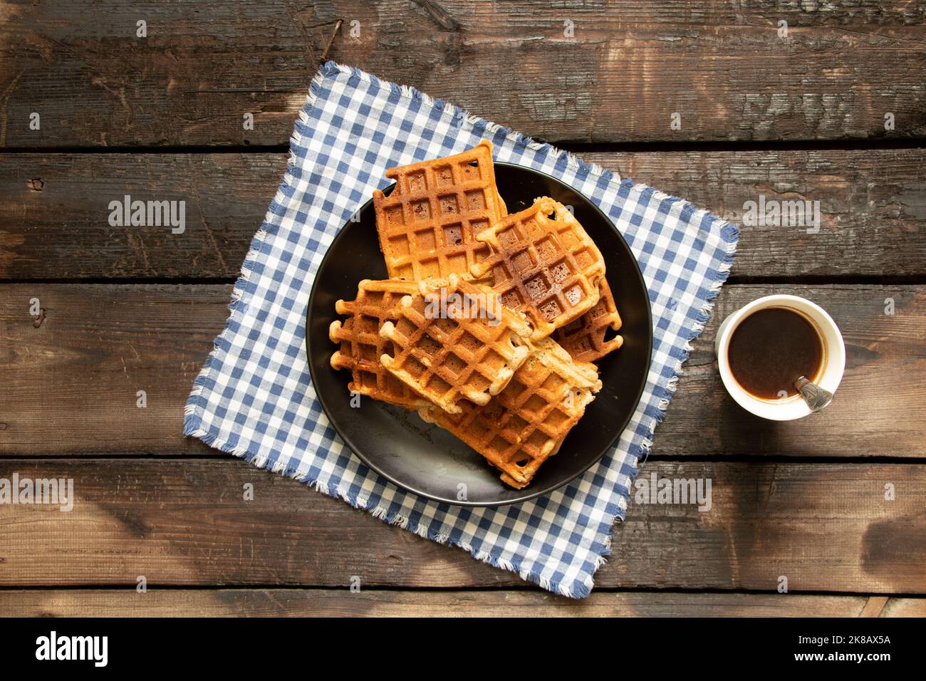 Wiener Waffel auf einem Holztisch und eine Tasse Kaffee, Waffeln zum Frühstück in der Küche zu Hause Stockfoto
