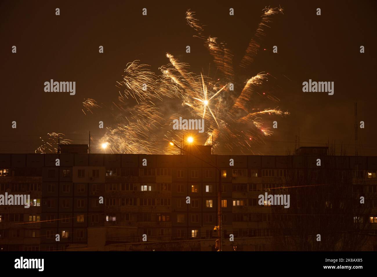 Feuerwerk am Nachthimmel vor dem Hintergrund von mehrstöckigen Gebäuden in einem Schlafbereich in der Ukraine, der Stadt Dnipro, Happy New Year 2022 Stockfoto