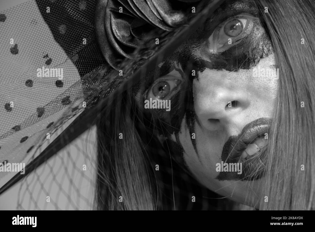 Hexe in einem Hut mit schwarzen Augen und Lippen, Hexenportrait, Halloween Urlaub, Make-up Stockfoto