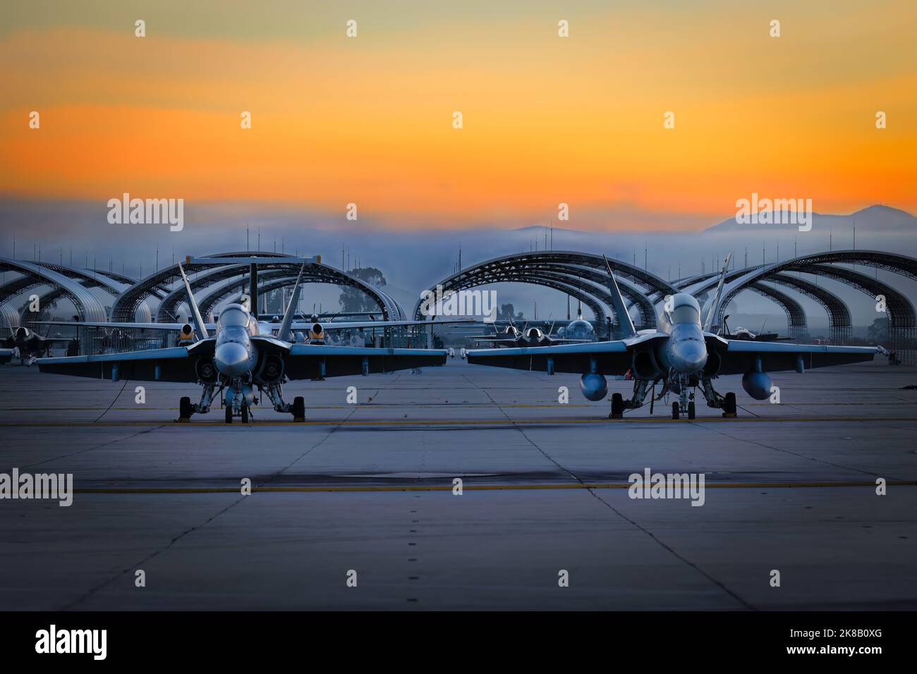 Zwei US Marine Corps FA-18 Hornets sitzen bei Sonnenaufgang auf dem Asphalt für die Miramar Airshow 2022 in San Diego, Kalifornien. Stockfoto