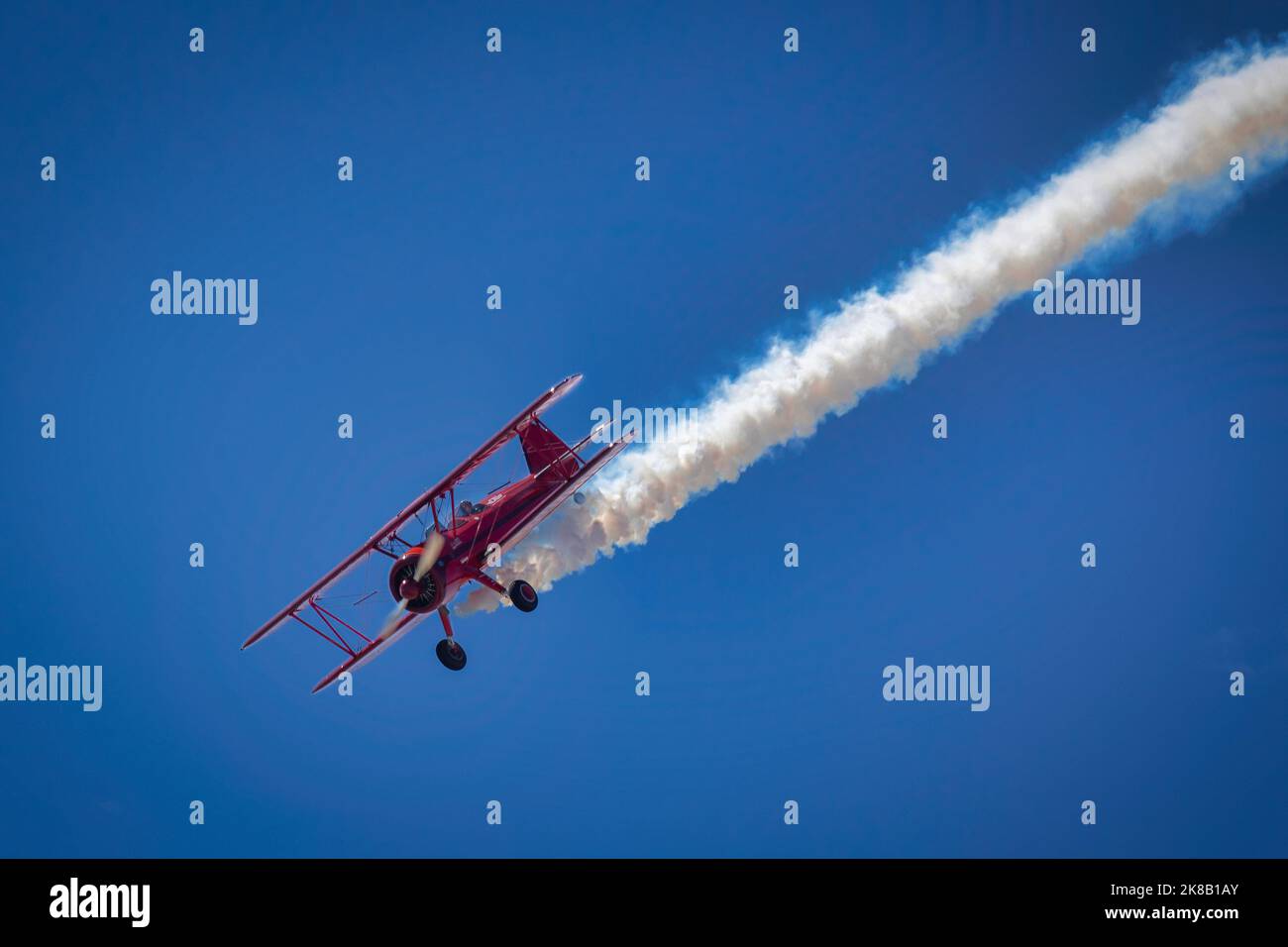 Vicky Benzing, eine erfahrene Airshow-Pilotin, taucht mit Rauch auf ihrem Doppeldecker Stearman 1940 auf der Miramar Airshow 2022 in San Diego, Kalifornien, in Richtung Erde Stockfoto