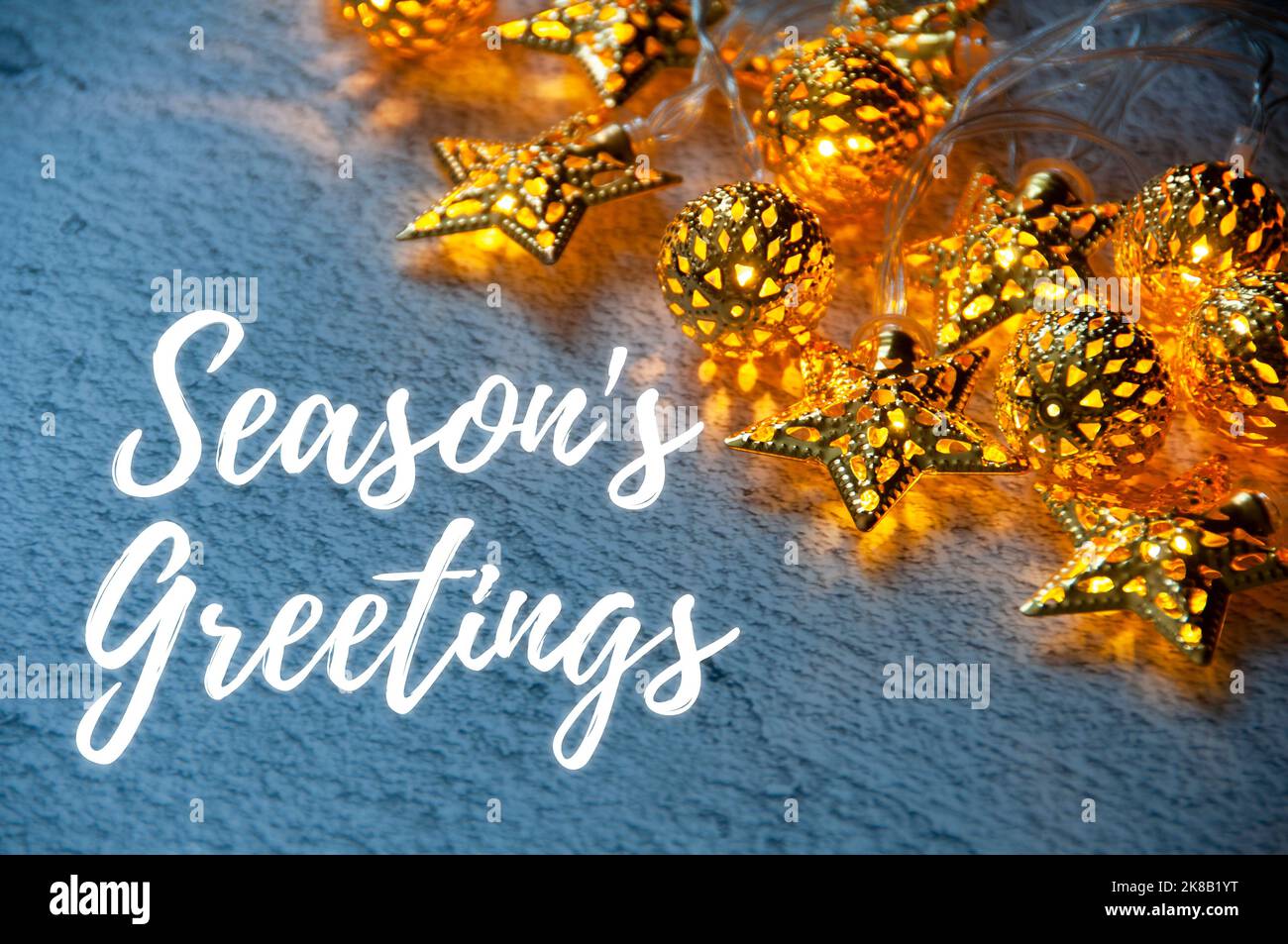 Season's Grußtext mit goldenen Weihnachtskugeln und beginnt hellen Hintergrund. Weihnachtszeit und Feier Stockfoto