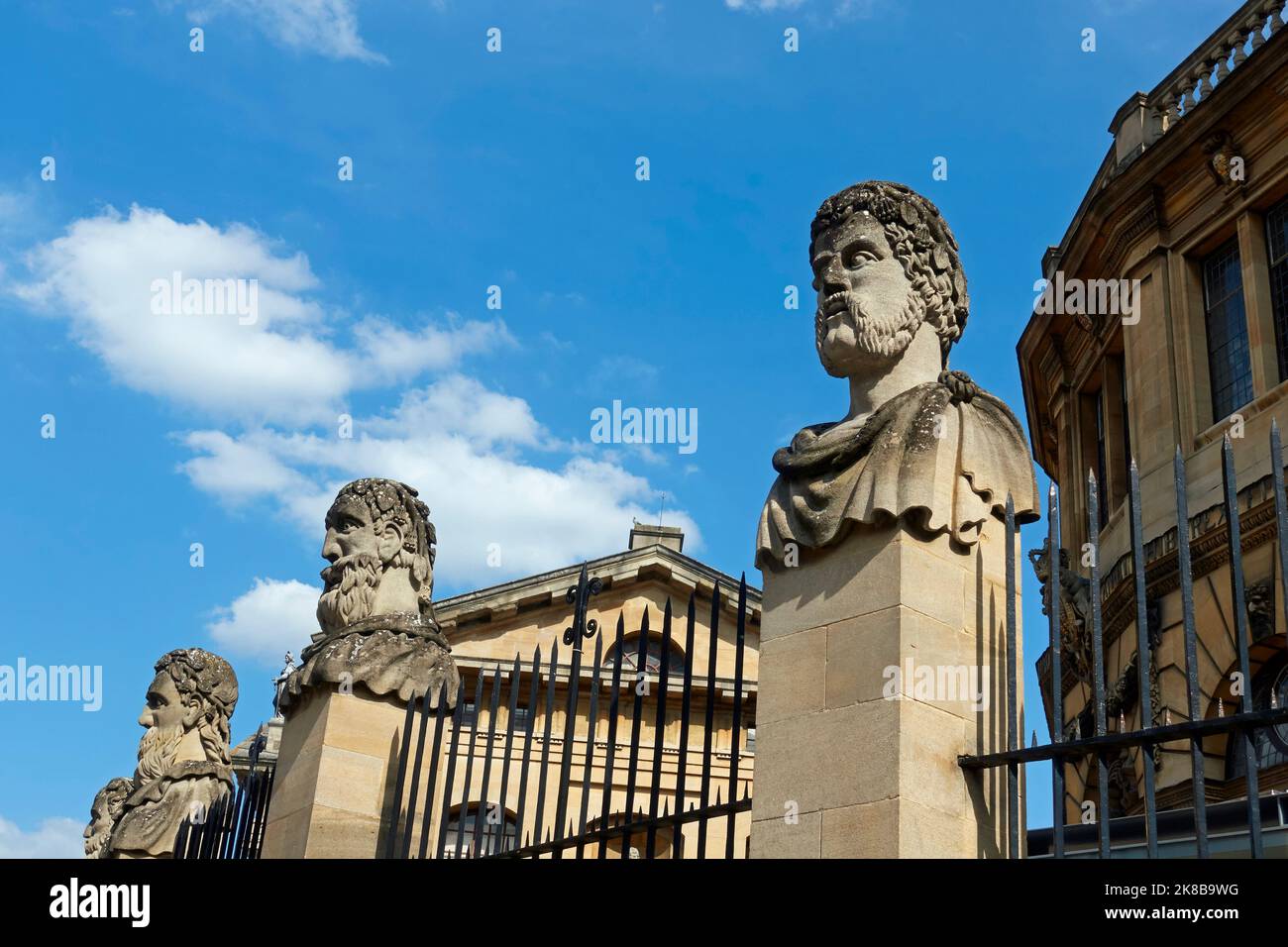 Drei der als „Emperor Heads“ bekannten Steinbüsten vor dem Sheldonian Theater, Broad Street, University of Oxford, Oxford, Oxfordshire, England. Stockfoto