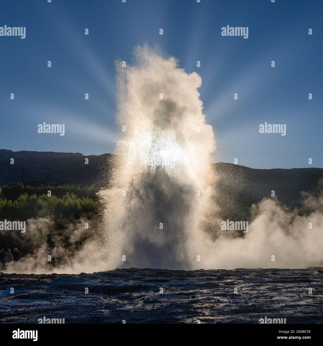 Strokkur Geyser Island, Abend mit Sonnenstrahlen, die durch die Wassersäule scheinen Stockfoto