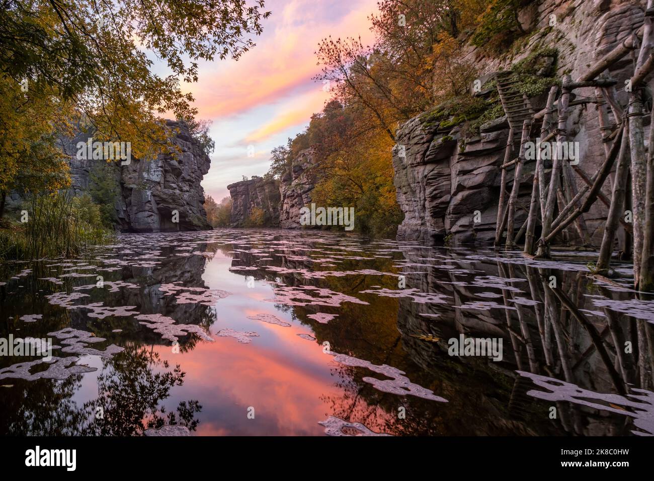 Erstaunliche Schlucht und Herbstlandschaft bei Sonnenaufgang. Fluss mit hohen Felsen im Wasser, Buky, Ukraine Stockfoto