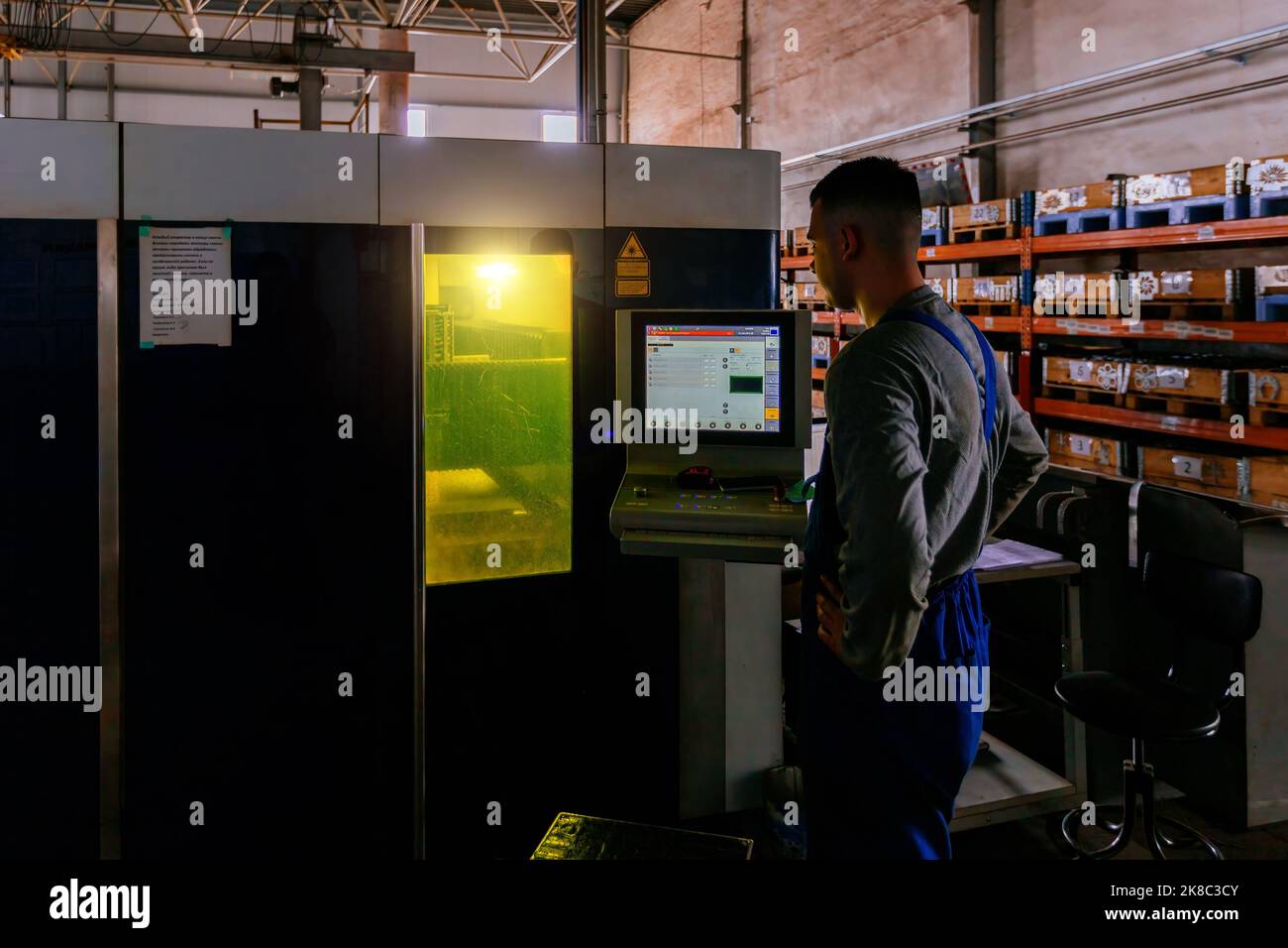 Der Bediener arbeitet mit der CNC-Laserschneidmaschine Stockfoto