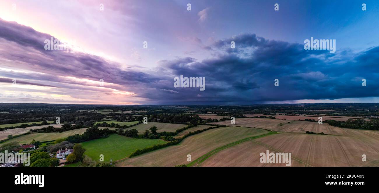 Landschaftspanorama zeigt dramatische Lüste, während ein Sturm sich bei Sonnenuntergang nähert ... Aufgenommen von Drone Stockfoto
