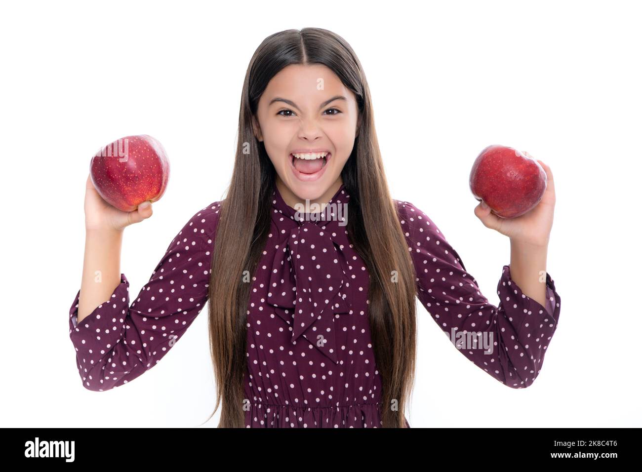 Kind Mädchen essen einen Apfel über isolierten weißen Hintergrund. Tennager mit Obst. Porträt der emotionalen erstaunt aufgeregt Teenager-Mädchen. Stockfoto