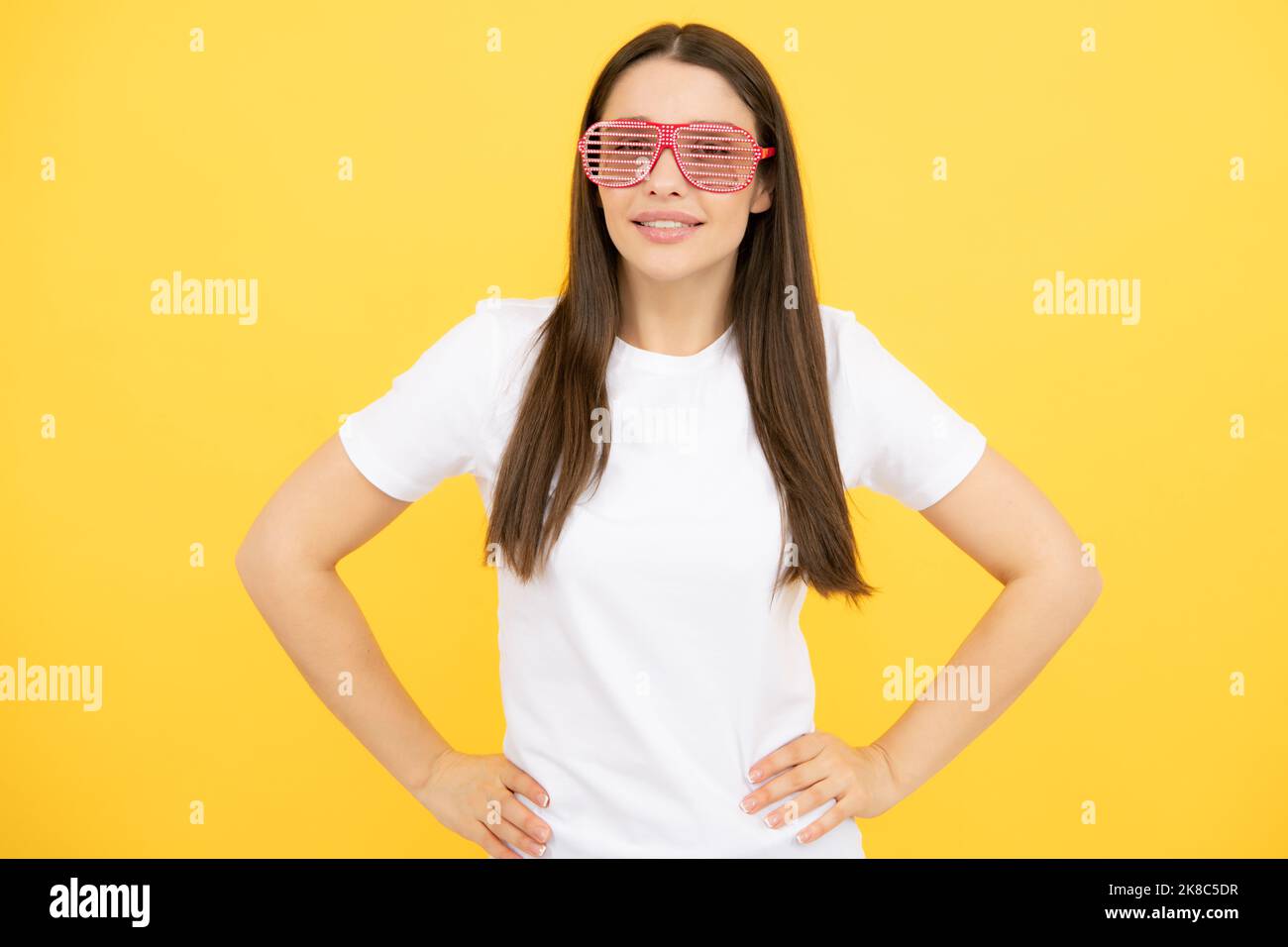 Fröhliches Mädchen in großen bif lustige Party Brille Sonnenbrille. Portrait einer jungen Frau, die eine lustige Brille auf gelbem Hintergrund trägt. Stockfoto