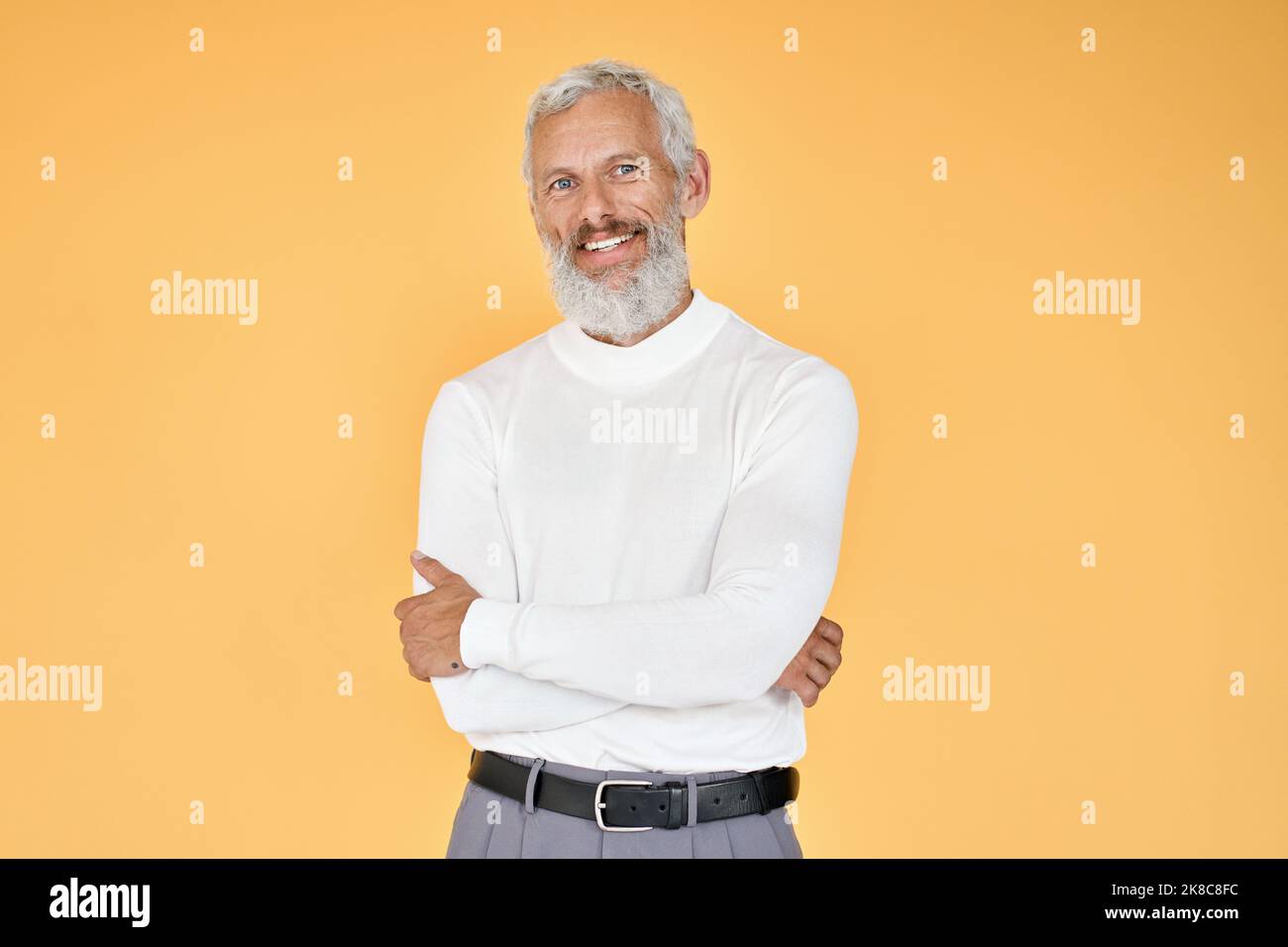 Glücklicher älterer Geschäftsmann, der isoliert auf gelbem Hintergrund steht. Stockfoto