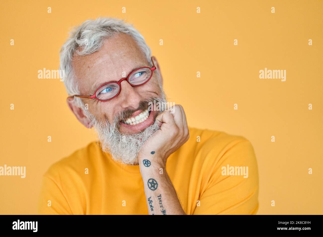 Gerissen aufgeregt älteren lustigen Mann wartet mit Vorfreude isoliert auf gelb. Stockfoto