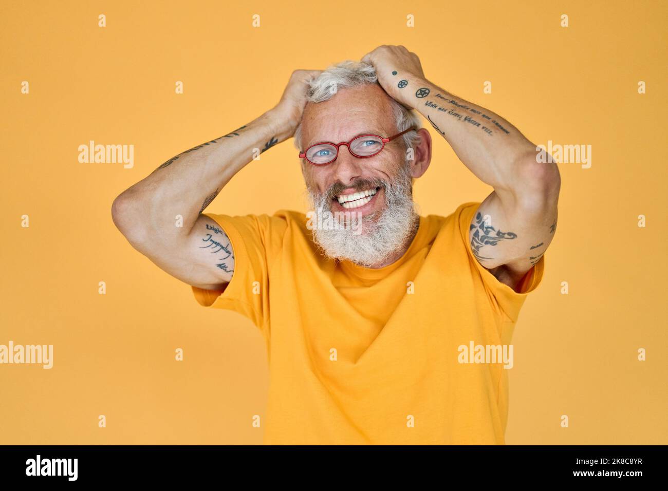 Glücklich lustig älteren bärtigen Hipster Mann trägt Brille isoliert auf gelb. Stockfoto