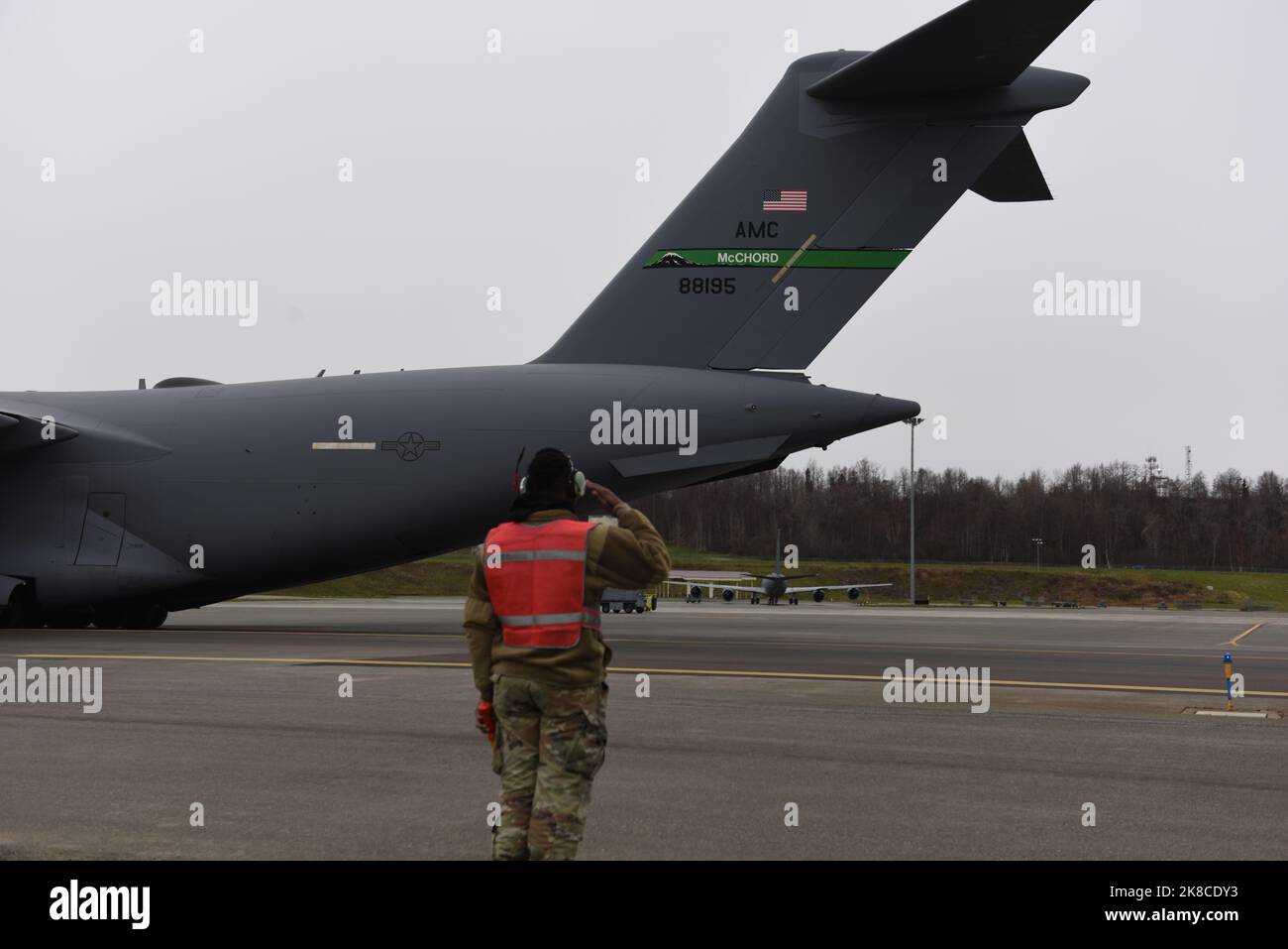 David Jones, Senior Airman der US Air Force, 62d Aircraft Maintenance Squadron Crew Chief, begrüßt einen C-17 Globemaster III, nachdem er ihn aus einem Parkplatz auf der Joint Base Elmendorf-Richardson, Alaska, am 12. Oktober 2022, geschickt hatte. Team McChord Airmen von der Joint Base Lewis-McChord, Washington, nehmen an der Übung RED FLAG-Alaska 23-1 in Verbindung mit der Übung Rainier war 22B Teil. Übung „Rainier war“ ist eine umfassende Bereitschaftsübung mit einer Priorisierung der Luftstreitkräfte, die die Fähigkeit demonstriert, während eines rigorosen Kriegsszenarios Kampftruppen zu erzeugen, einzusetzen und aufrechtzuerhalten. (USA Stockfoto