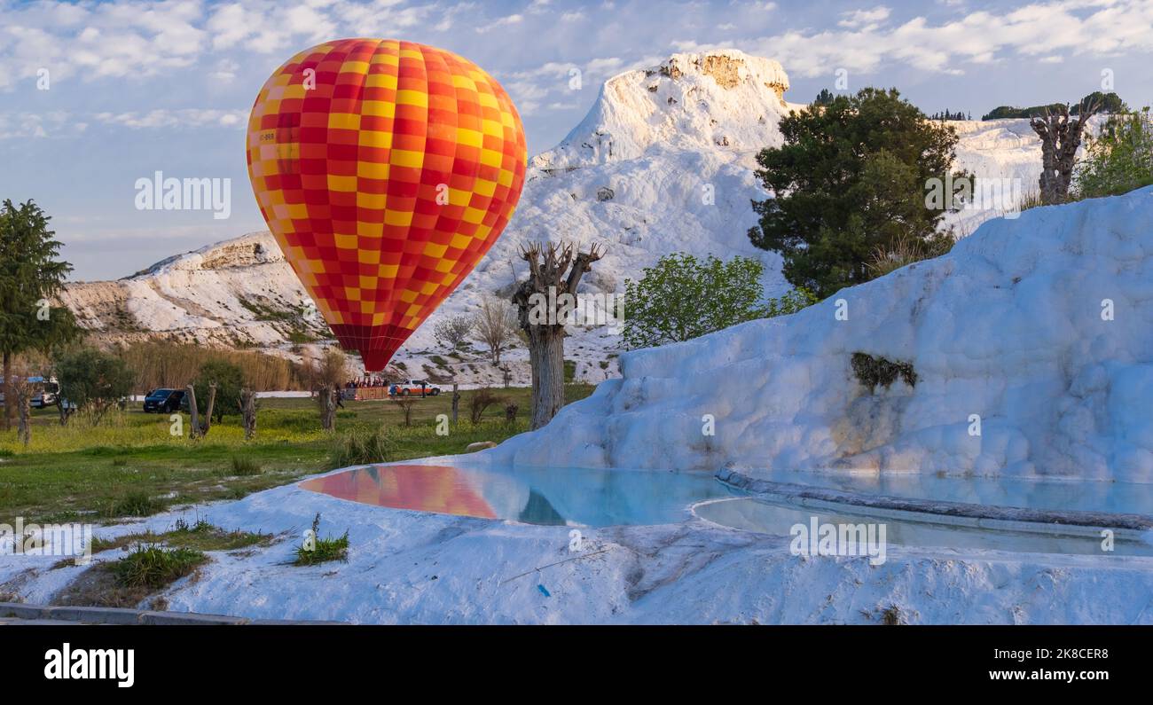 Heißluftballon fliegt über Travertin Pools Kalksteinterrassen an einem schönen Tag. Pamukkale, Denizli, Türkei. Stockfoto