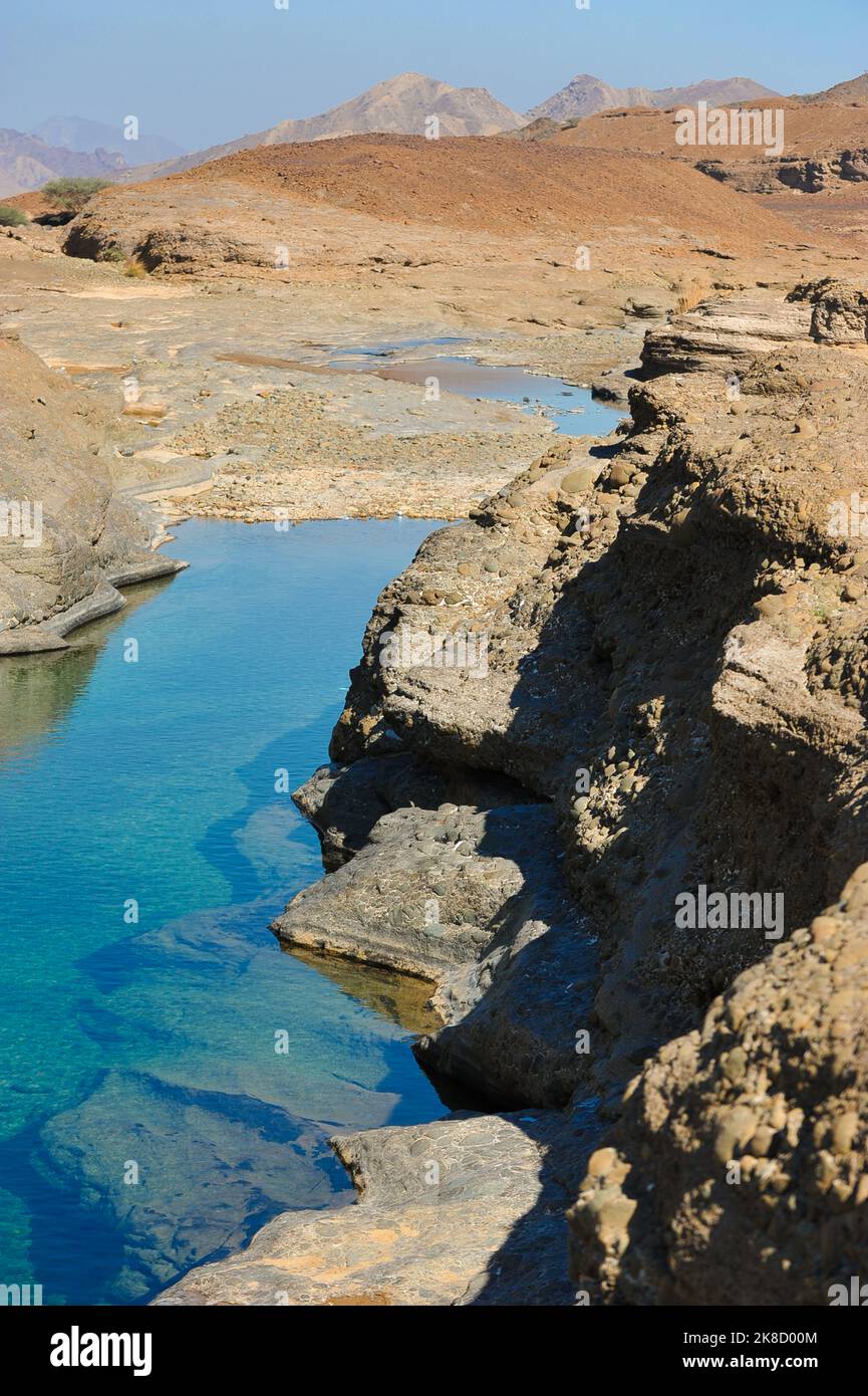 Frischer, klarer Felsenpool in Hatta, einer Exklave im Landesinneren von Dubai, VAE. Exotisches Wadi Al Qahfi an einem Sommertag. Felsige, zerklüftete Landschaft mit lebhaftem Wasser. Stockfoto