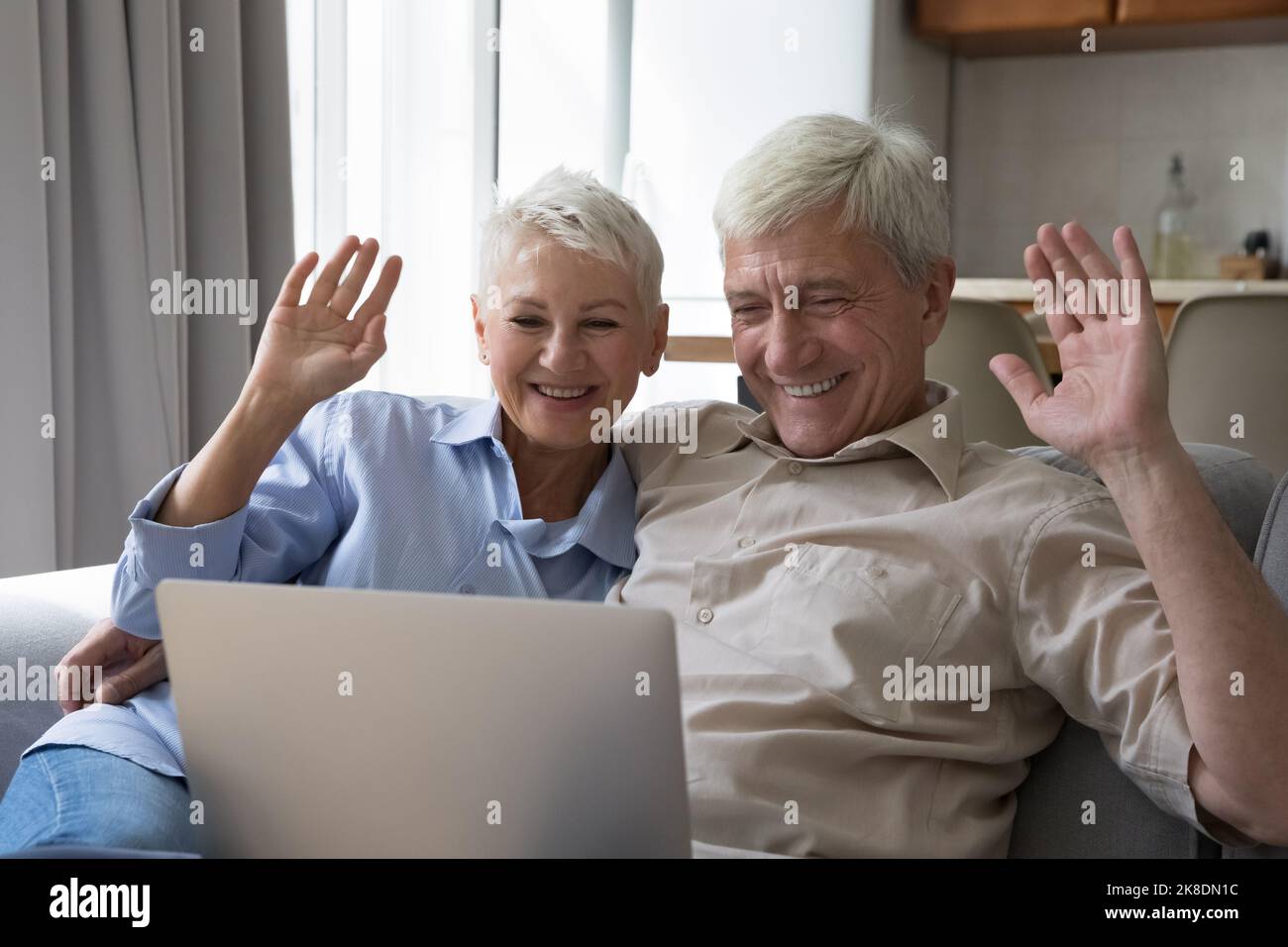 Attraktive ältere Frau und Ehemann mit Laptop starten Videoanruf Stockfoto