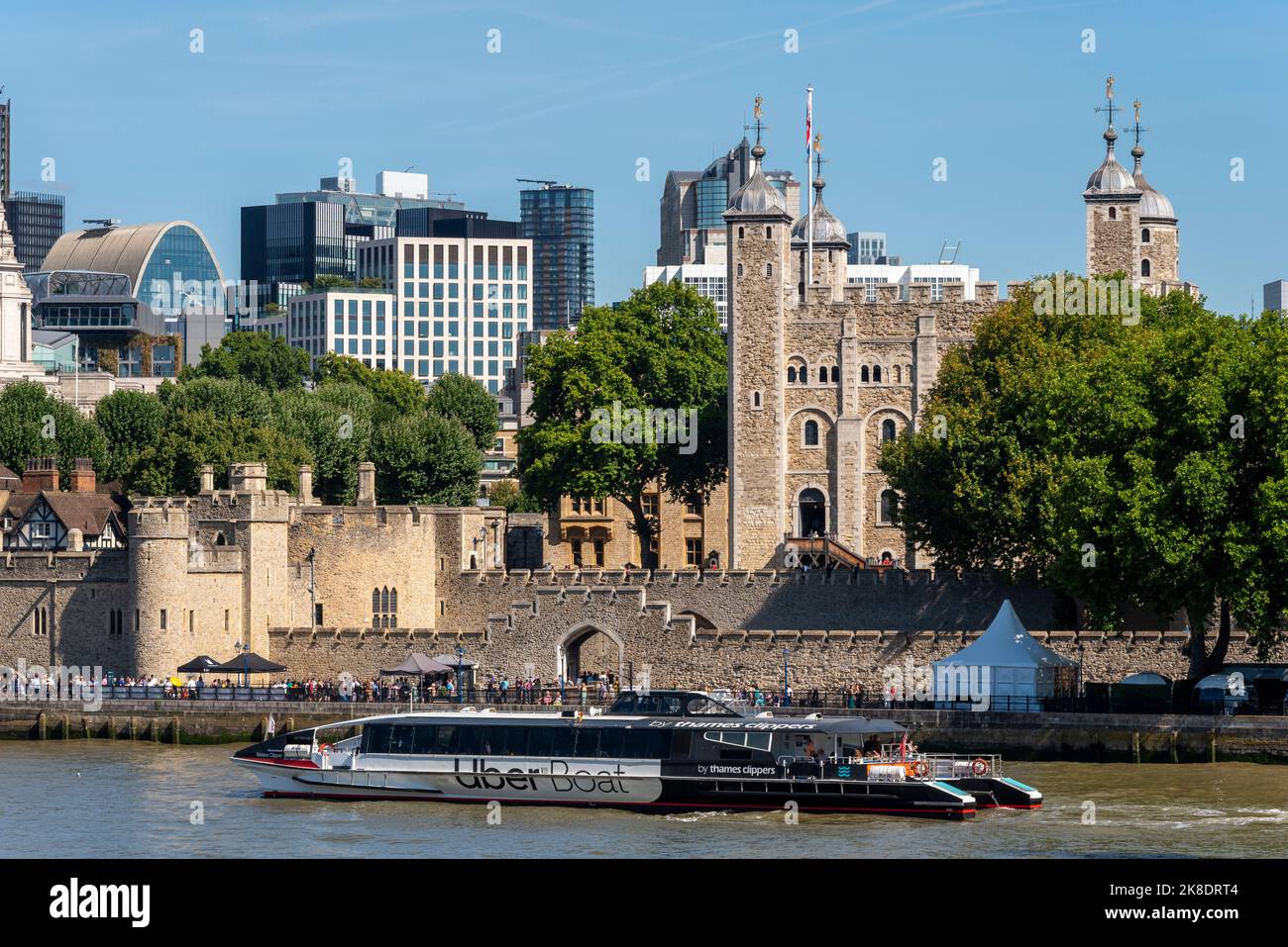 Uber Boat Flussbusschiff auf der Themse, vorbei am Tower of London, Großbritannien. Bootsservice mit dem Flusstaxi. Weißer Turm und Wände Stockfoto