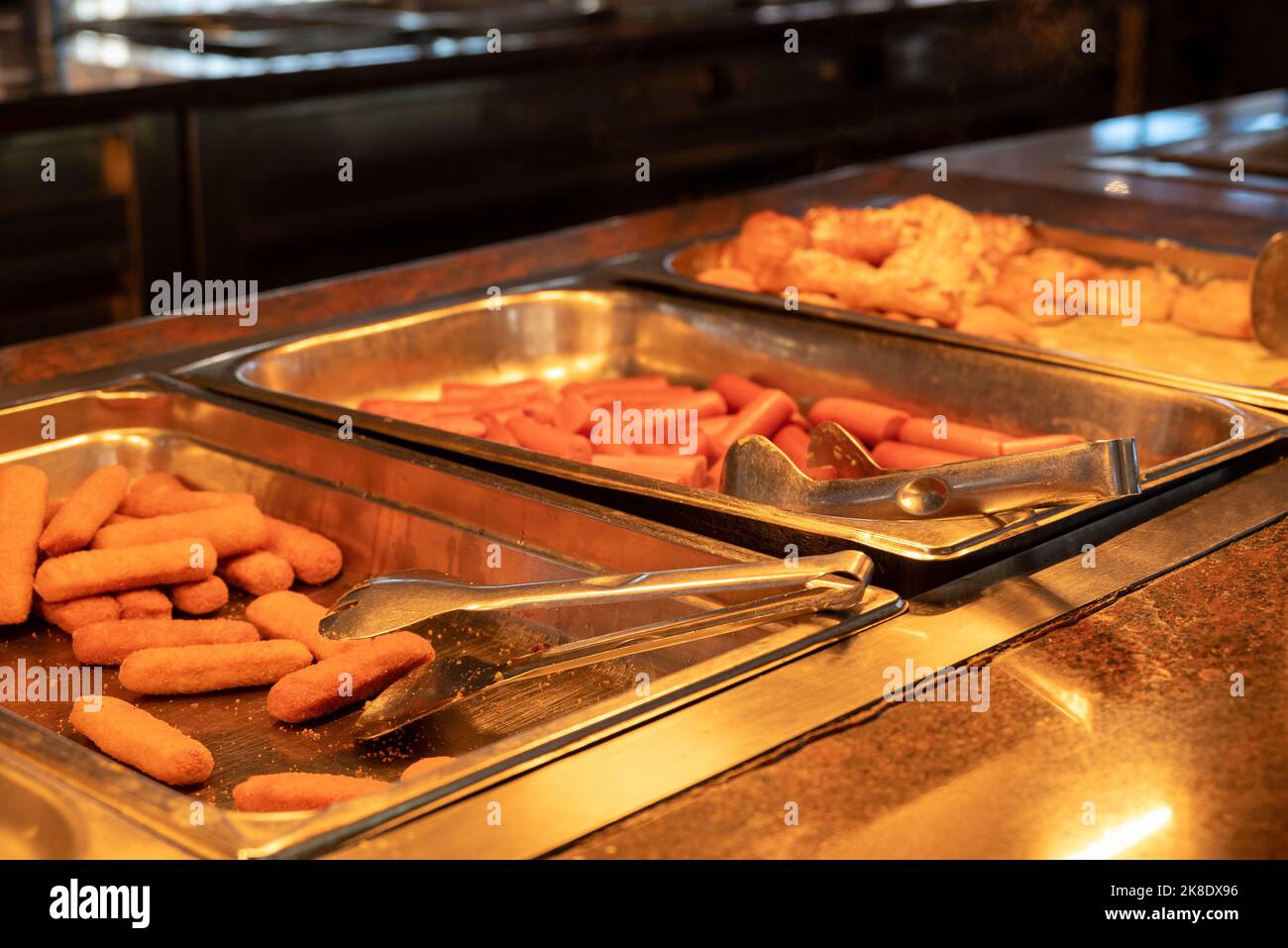 Buffet - Speisen Auf Heißen Tabletts - Fischfinger, Würstchen Und Brötchen. Fast Food. Stockfoto