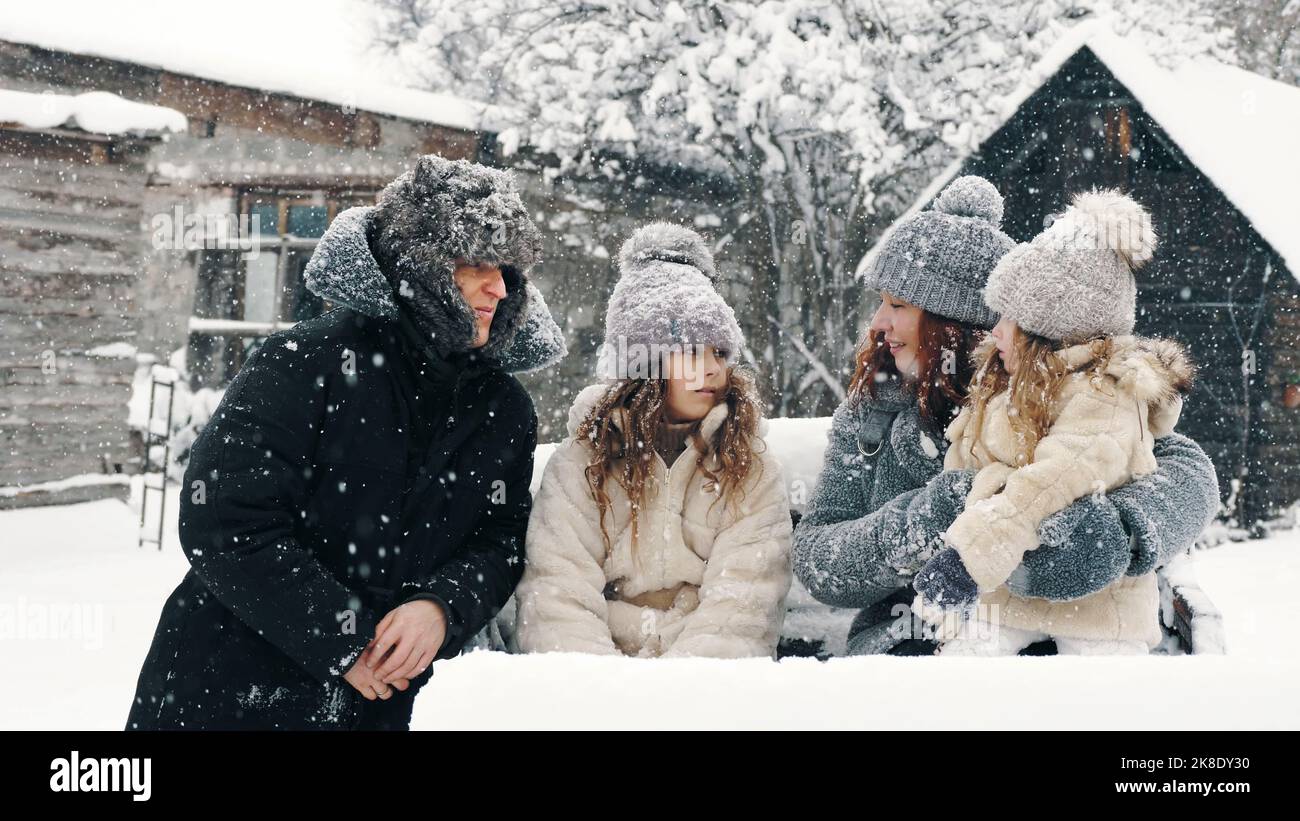 Winterspaß für die ganze Familie. Glückliche Familie von 4 Jahren genießt Schnee und Schneefall, Spaß im Freien, verbringen Zeit zusammen am verschneiten Wintertag. Zeitlupe. Hochwertige Fotos Stockfoto