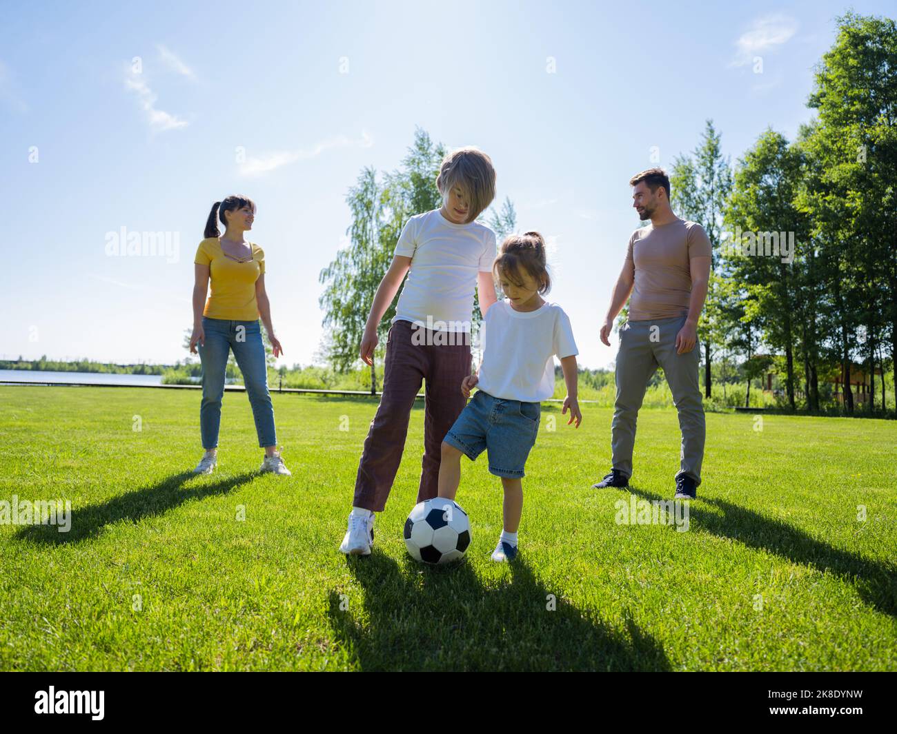 Glückliche Familie mit zwei Kindern spielt in ihrer Freizeit Fußball Stockfoto