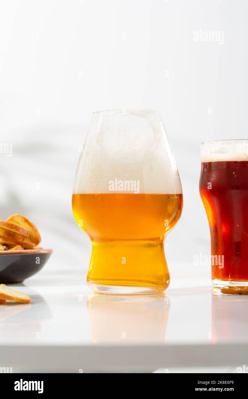 Ein Glas helles Bier und auf dunklem Glas mit schaumweißer Oberfläche Essen und Trinken Stockfoto