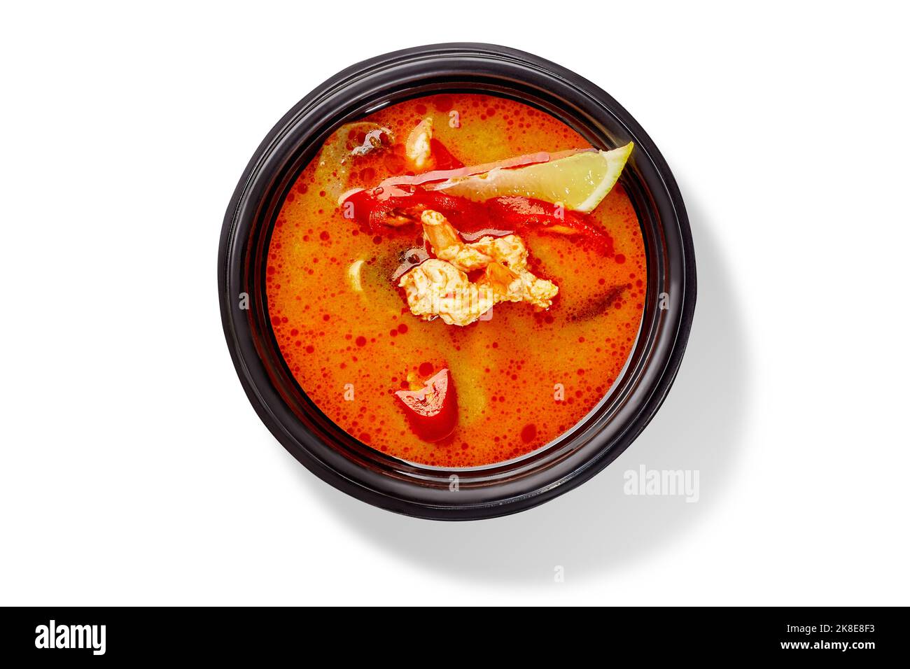 Schüssel mit Thai-Suppe tom Yam mit Huhn, roter Chilischote und Zitrone Stockfoto