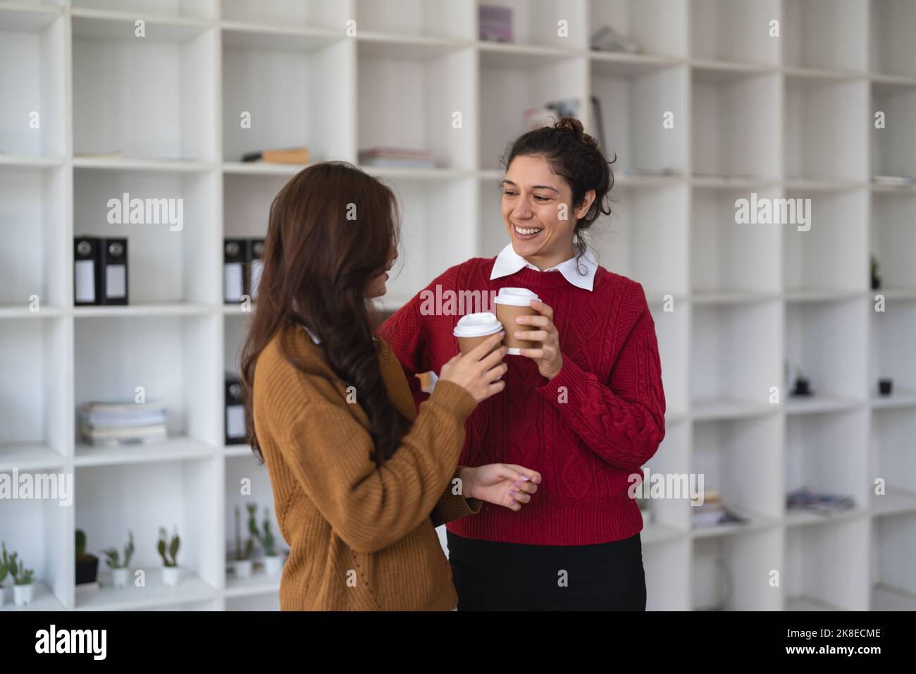 Diverse freundliche Mitarbeiter Kaffeepause Gespräch Büro. Kaukasischer Manager, der in der Bürolobby Gespräche mit asiatischen Mitarbeitern führt Stockfoto