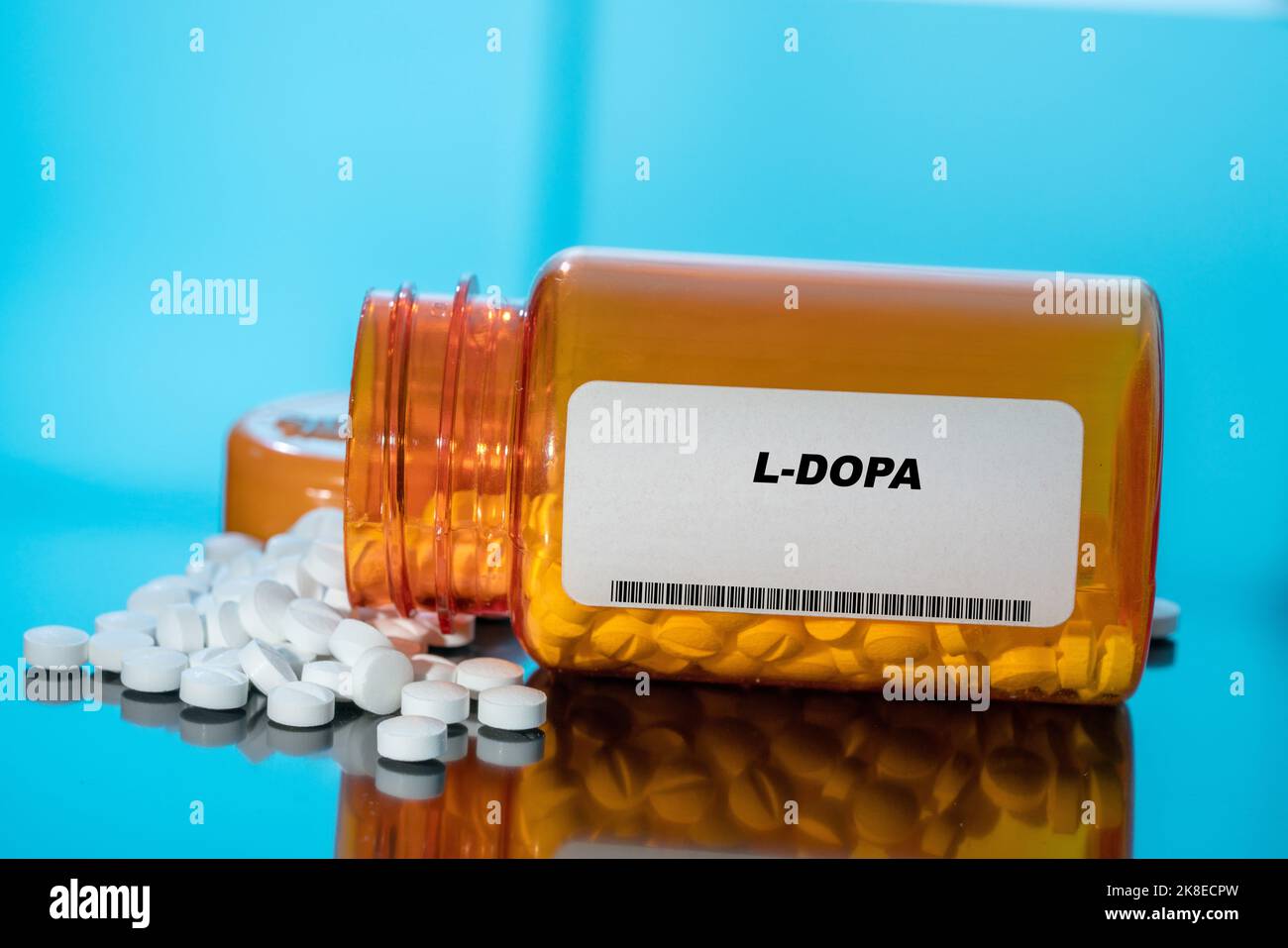 L-Dopa weiße medizinische Pillen und Tabletten, die aus einer Drogenflasche verschüttet werden. Makro-Ansicht von oben nach unten mit Kopierbereich. Stockfoto