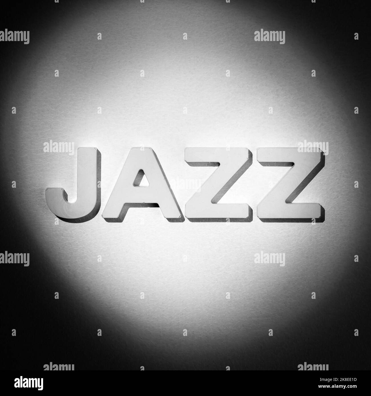 Jazz - Wort durch weiße geformte Buchstaben in hellem Spotlicht. Schwarzweiß-Bild Stockfoto