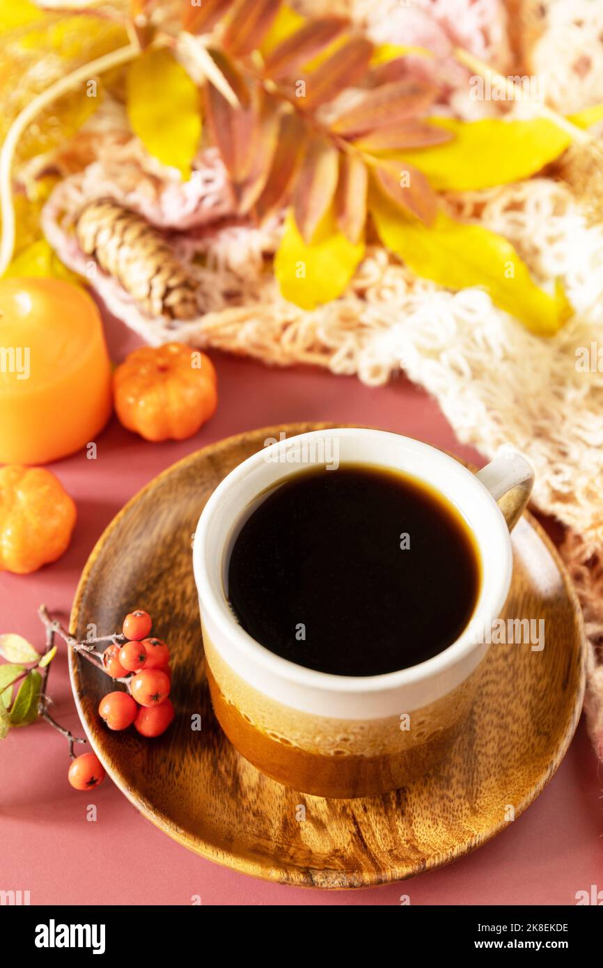 Zusammensetzung Herbstblätter, heiße Tasse Kaffee und warmes Tuch. Herbstliches Frühstück. Gemütliches Herbstkonzept. Stockfoto