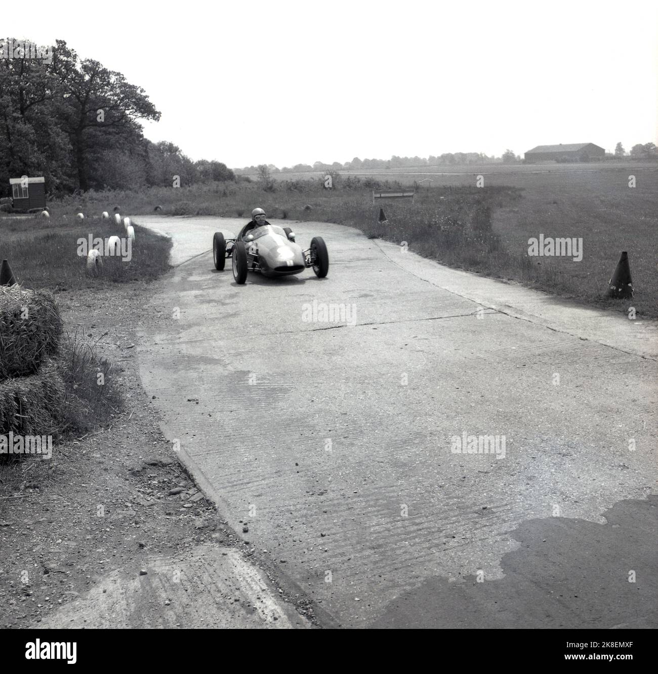 1962, historisch, ein einsitziger Rennwagen auf der schmalen Rennstrecke, die umfahrende Straße bei Finmere Aerodome, einem stillstehenden RAF-Flugplatz in der Nähe von Buckingham, England, Großbritannien, wo Geoff Clarke's Motor Racing Stables beheimatet ist. Die 1.000-ccm-Einsitzer der Rennschule waren Formel-Junior-Coopers mit Heckmotor. Stockfoto