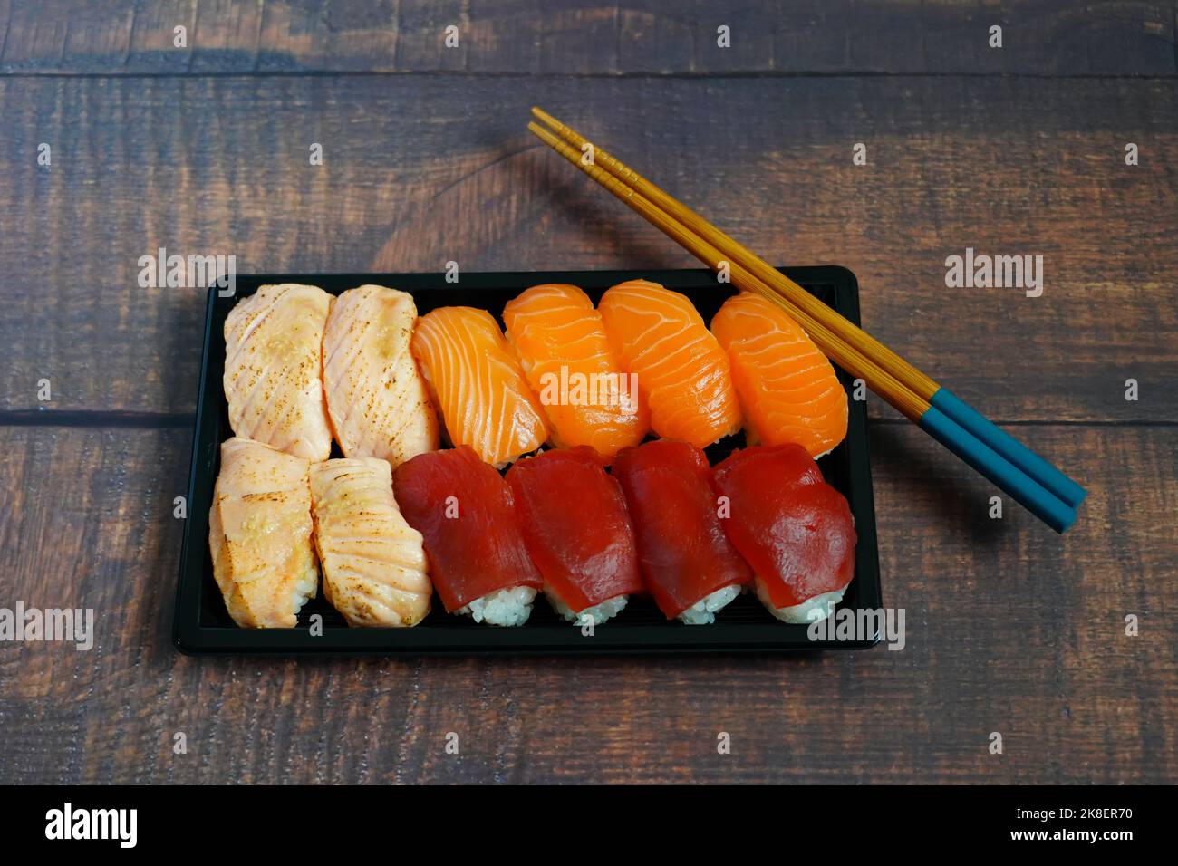 Sushi-Box mit Nigiri-Sushi: Aburi-Sake, Sake und Maguro (Lachs und Thunfisch). Stockfoto