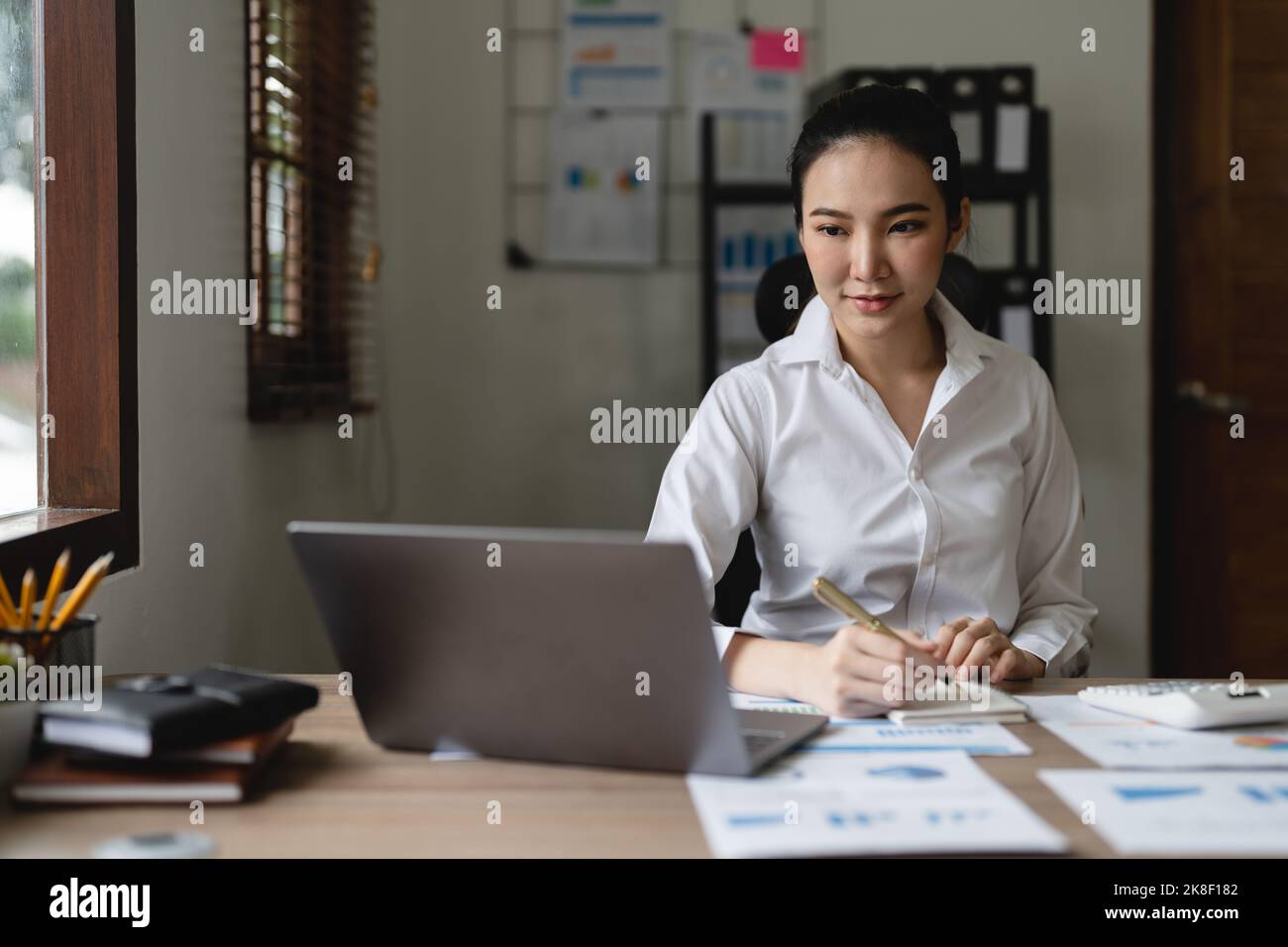 Frau Buchhalterin mit Rechner und Laptop-Computer im Büro, Finanzen und Buchhaltung Konzept Stockfoto