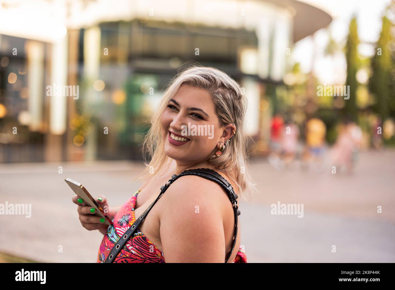 Glückliche junge Frau mit Mobiltelefon Stockfoto