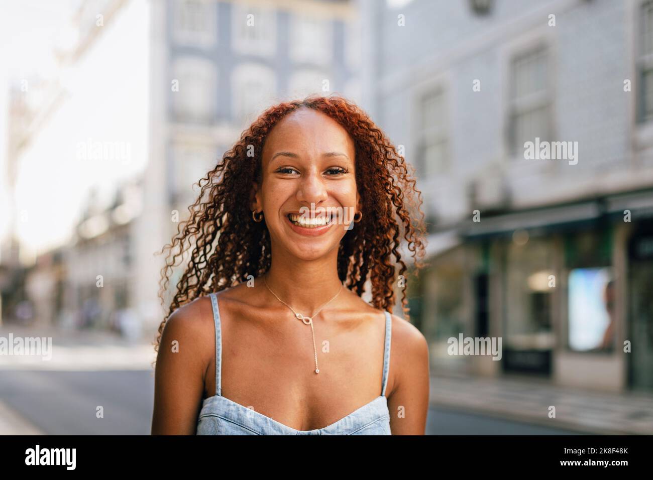 Glückliche schöne junge Frau mit lockigen Haaren Stockfoto